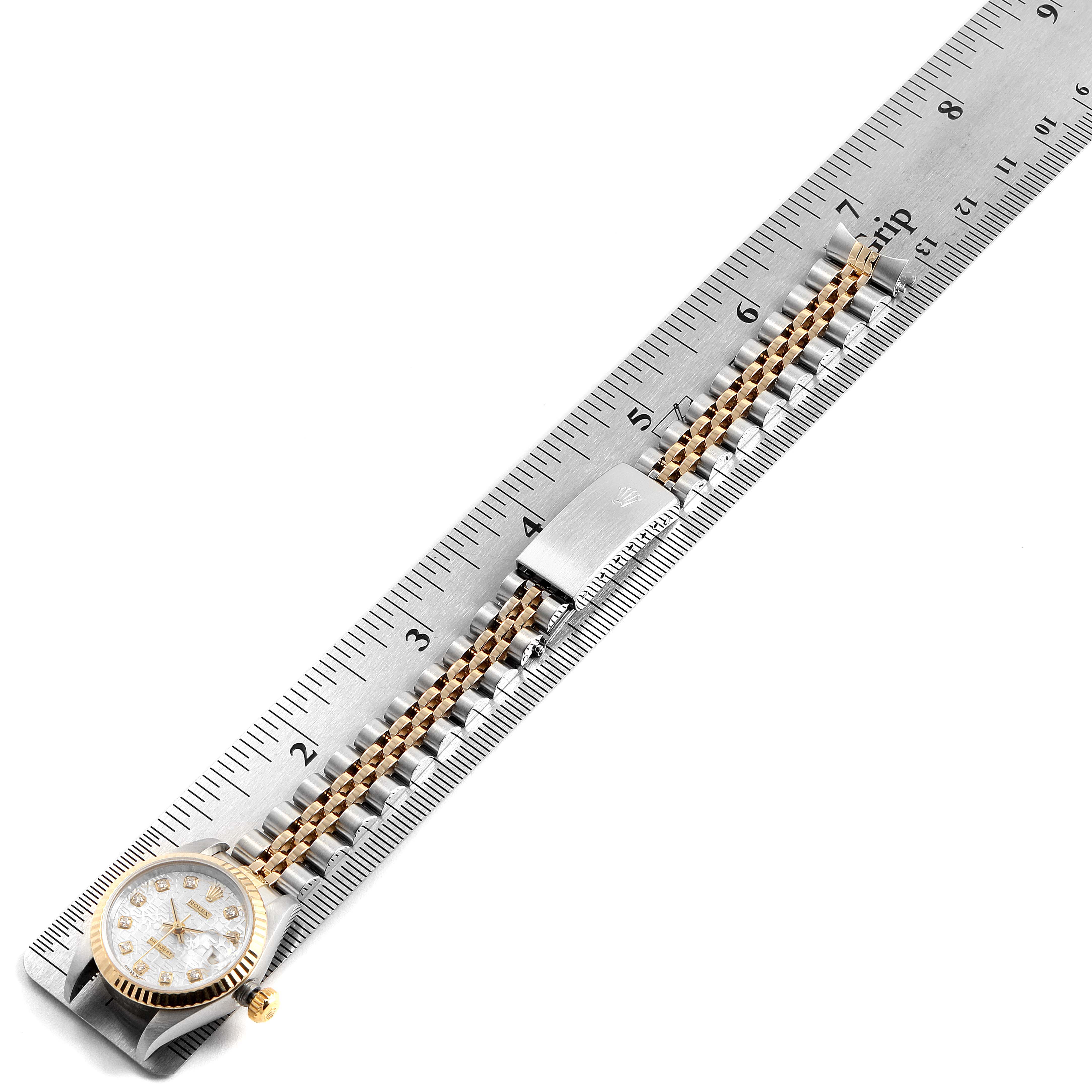 The Rolex Datejust 69173 Women's Stainless Steel Silver Dial 69173 Women's Stainless Steel Silver Dial watch is shown from a top view along a ruler, displaying its case, bracelet, and clasp.