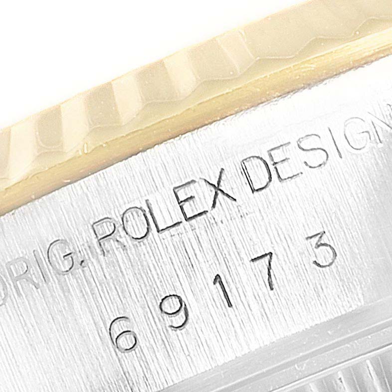 The image shows a close-up of the serial number and "ROLEX DESIGN" engraving on the side of the Rolex Datejust 69173 Women's Stainless Steel Silver Dial 69173 Women's Stainless Steel Silver Dial watch case.
