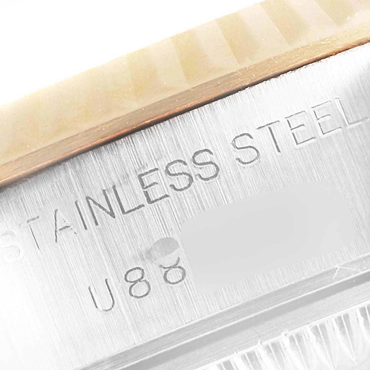 This close-up image shows the engraved serial number and "STAINLESS STEEL" text on the side of the Rolex Datejust 69173 Women's Stainless Steel Silver Dial 69173 Women's Stainless Steel Silver Dial watch case.