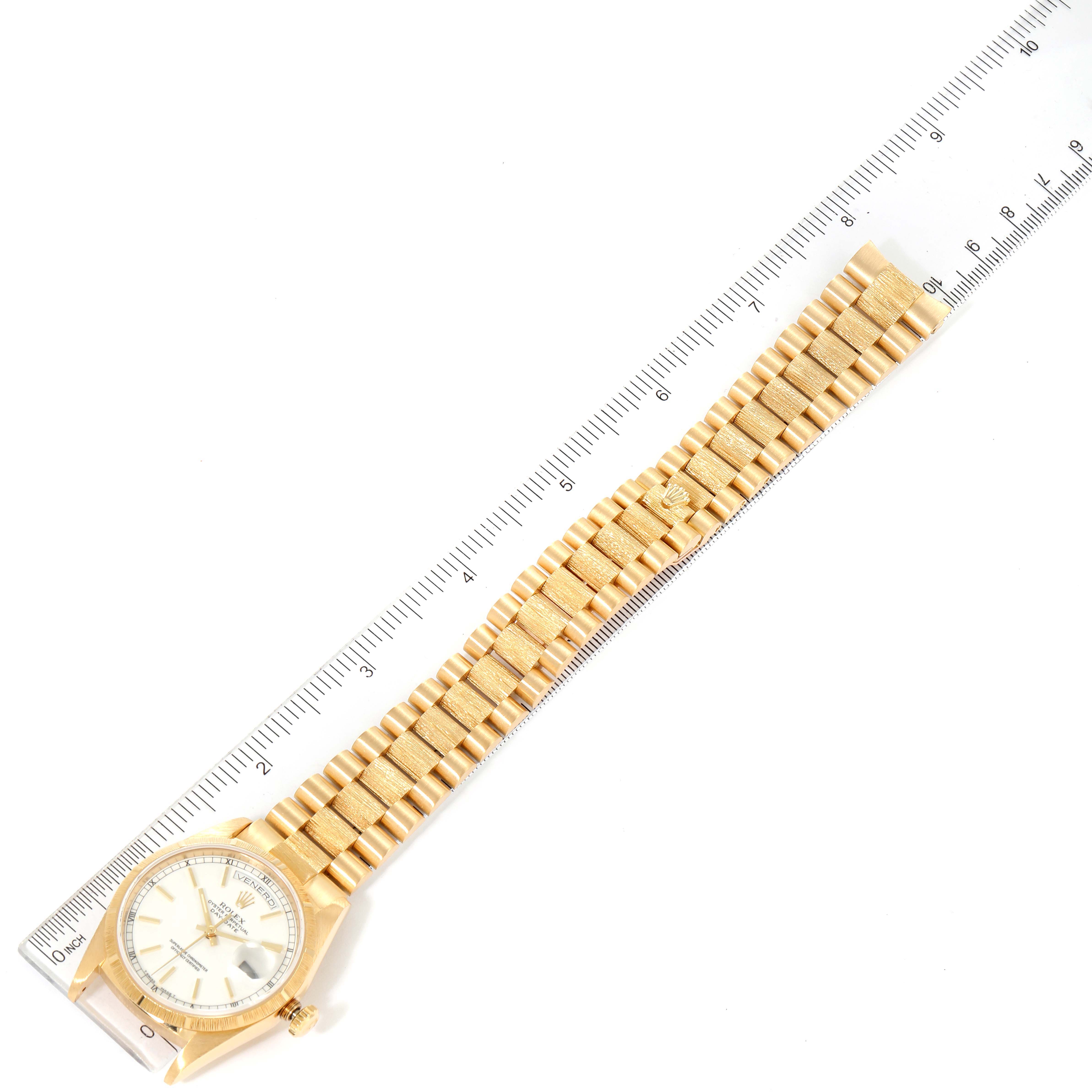This image shows a Rolex President 18248 Men's Yellow Gold White Dial 18248 Men's Yellow Gold White Dial model watch laid flat next to a ruler, displaying its face and entire bracelet.