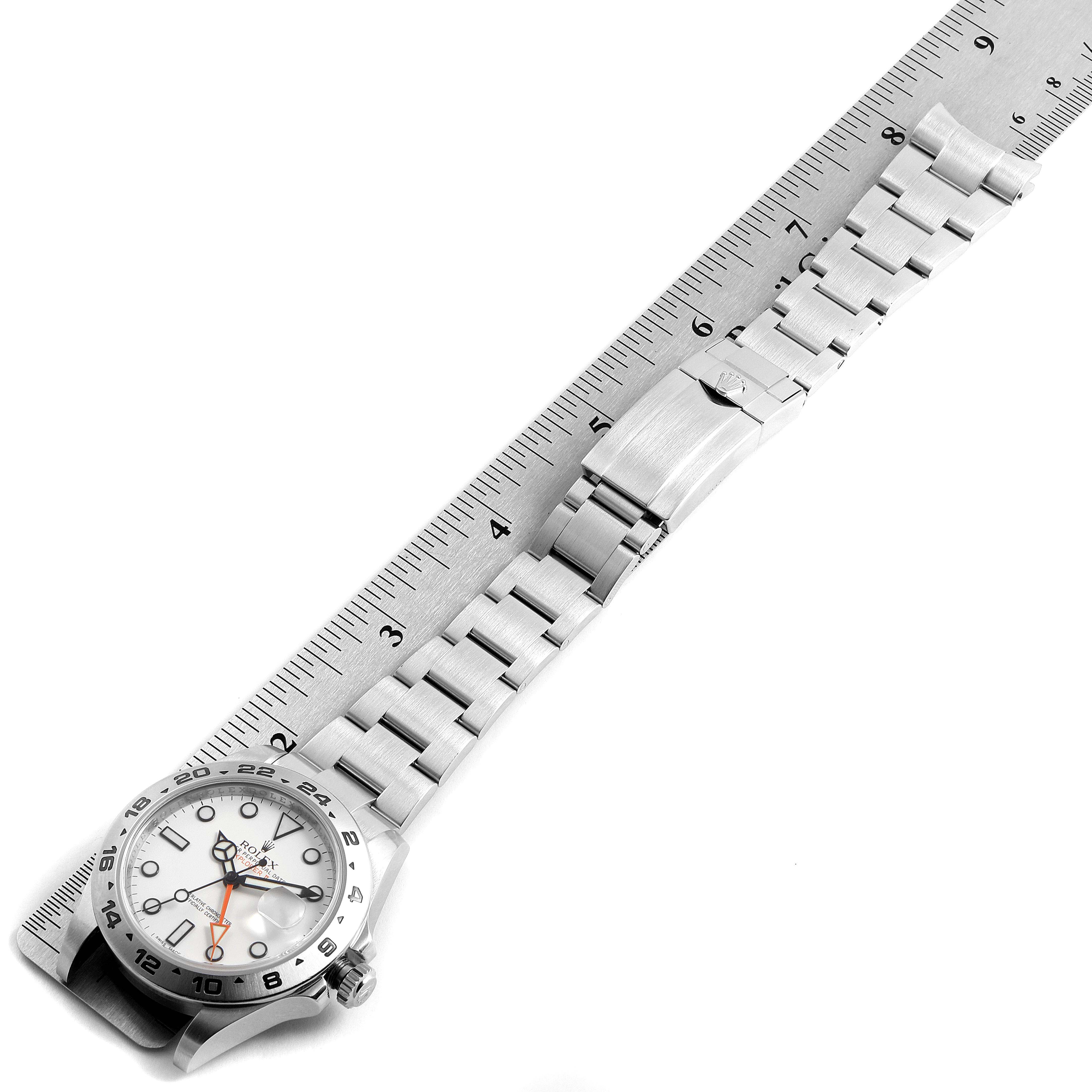 The image shows a Rolex Explorer 216570 Men's Stainless Steel White Dial 216570 Men's Stainless Steel White Dial watch laid flat next to a ruler, displaying both the face and the fully extended metal band.