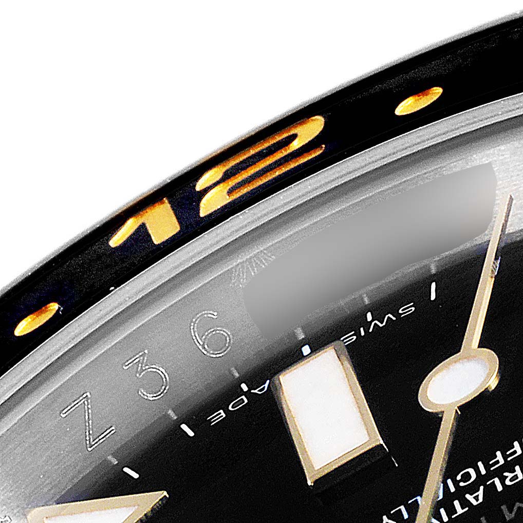 The image shows a close-up of the dial, bezel, and part of the minute hand of a Rolex GMT-Master 116713 Men's Steel and Gold (two tone) Black Dial 116713 Men's Steel and Gold (two tone) Black Dial watch.
