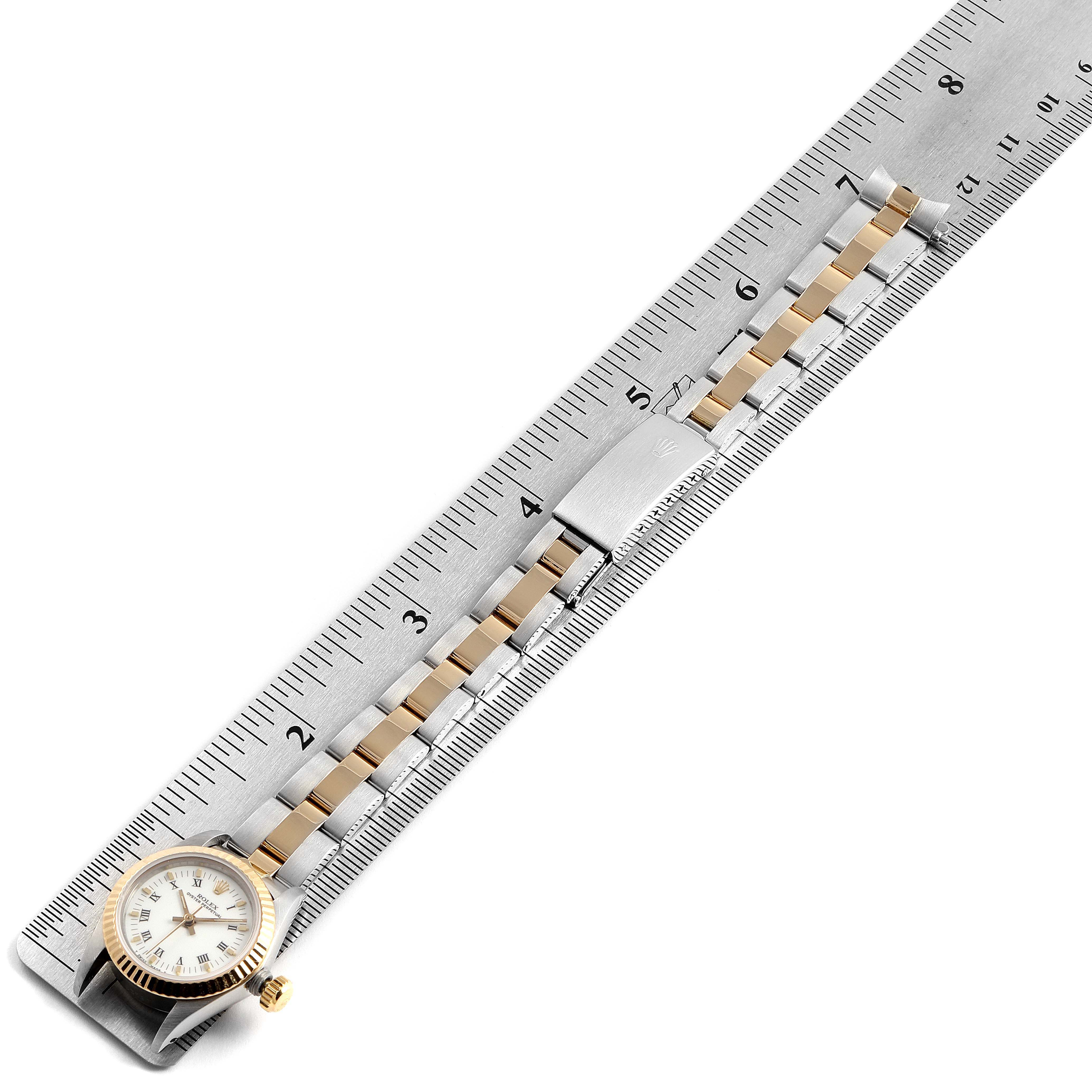 The Rolex Datejust 67193 Women's Steel and Gold (two tone) White Dial 67193 Women's Steel and Gold (two tone) White Dial watch is shown from an overhead view, displaying the dial, bezel, and bracelet placed alongside a ruler.