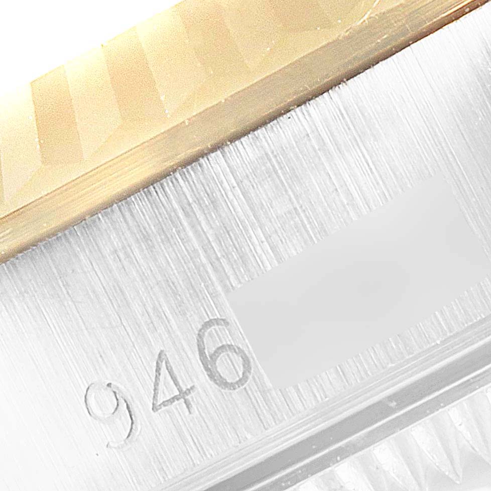 This close-up image shows part of the bezel and the case of a Rolex Datejust 67193 Women's Steel and Gold (two tone) White Dial 67193 Women's Steel and Gold (two tone) White Dial model watch, highlighting its metallic and engraved details.