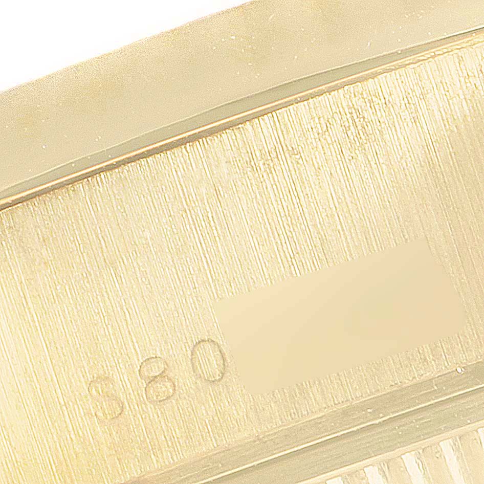 This close-up image shows a part of the engraved serial number on a Rolex President 69178 Women's Yellow Gold White Dial 69178 Women's Yellow Gold White Dial model.
