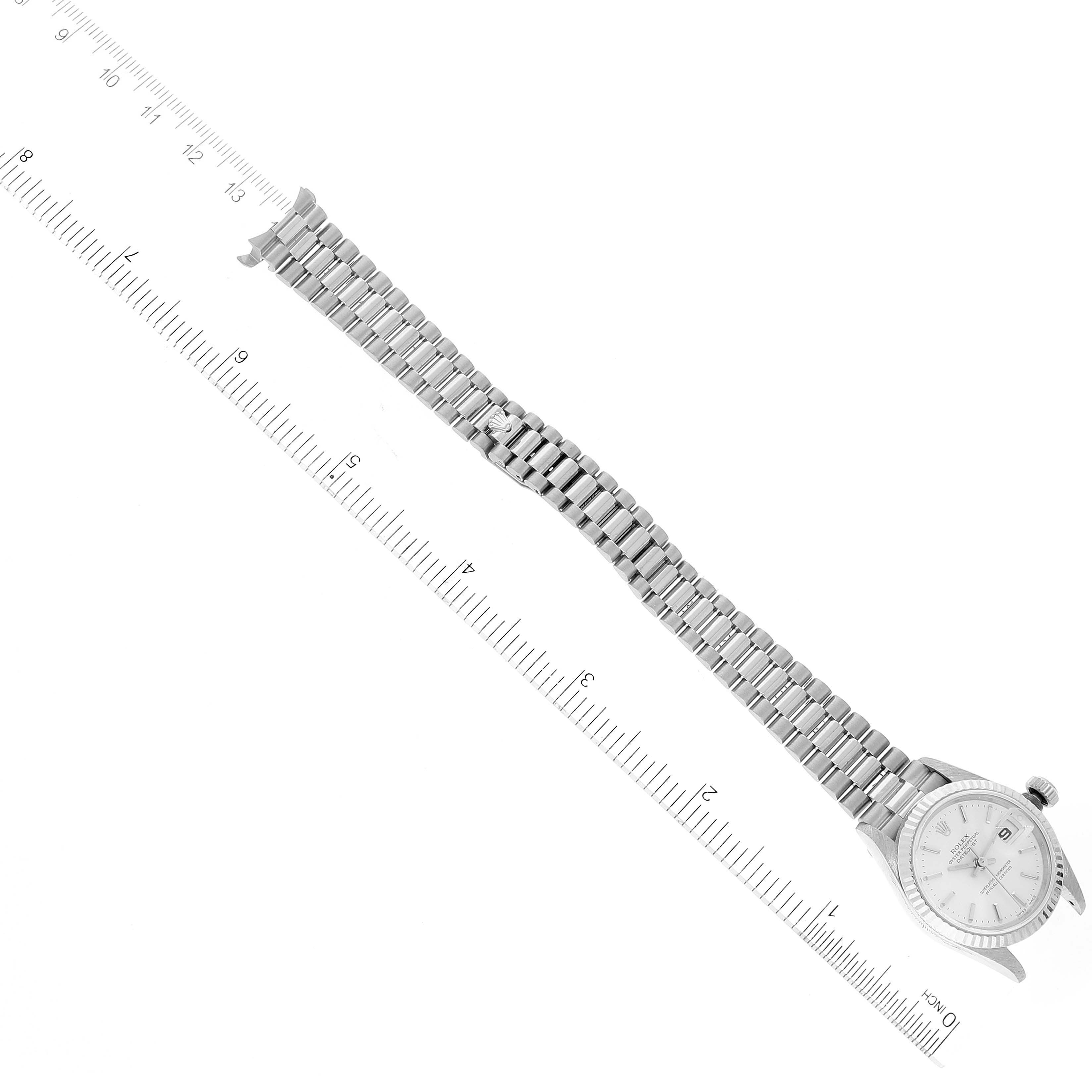 The image shows a Rolex President 79179 Women's White Gold Silver Dial 79179 Women's White Gold Silver Dial model watch laid flat with both the face and bracelet visible, positioned along a ruler.