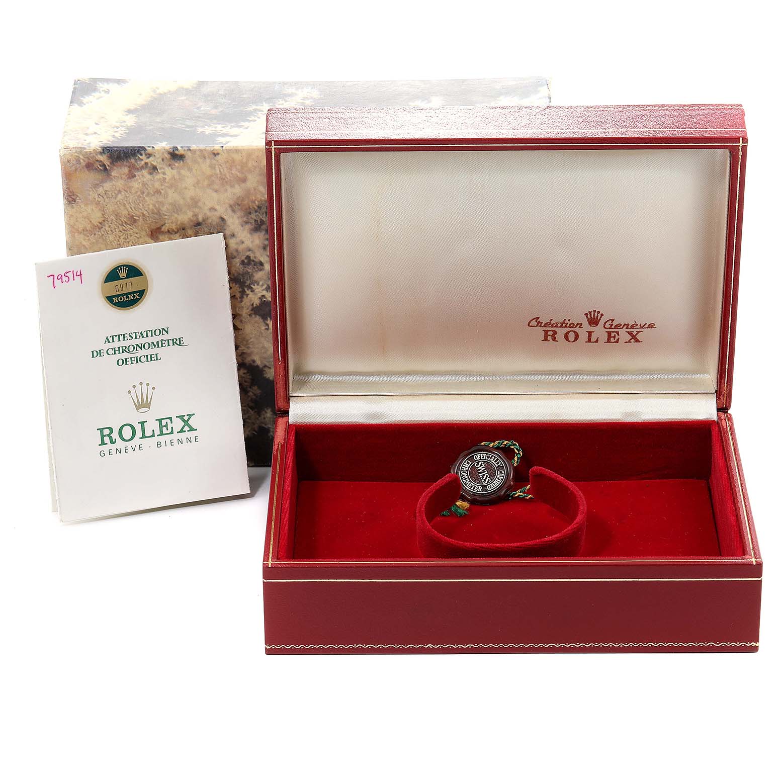 The President model Rolex watch is shown with its case and official certification booklet at an angled top view.