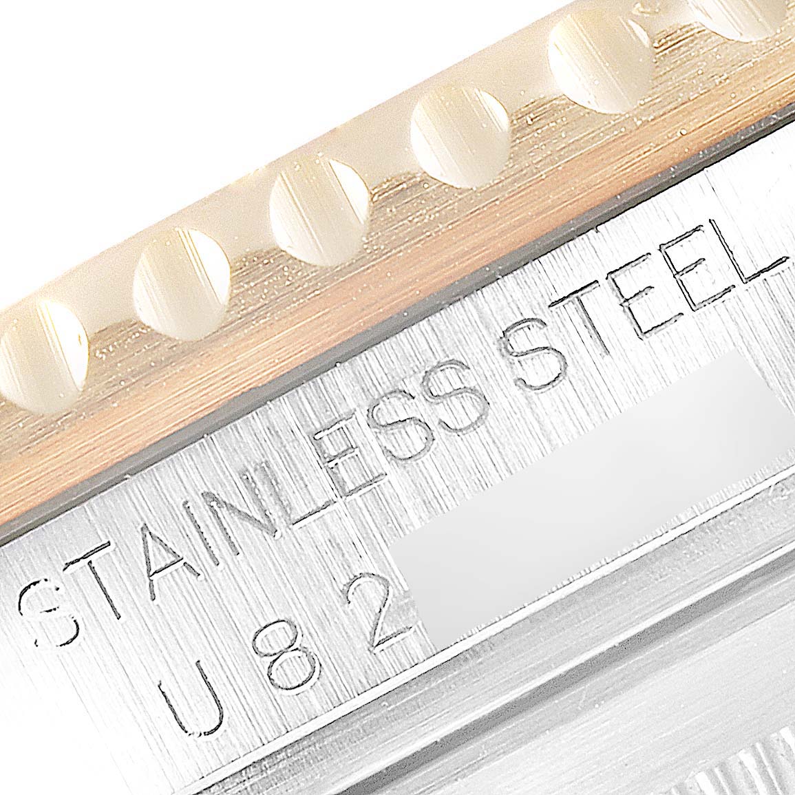 The image shows a close-up of the Rolex Submariner 16613 Men's Steel and Gold (two tone) Blue Dial 16613 Men's Steel and Gold (two tone) Blue Dial watch's bezel edge and part of the stainless steel case with engraved text.