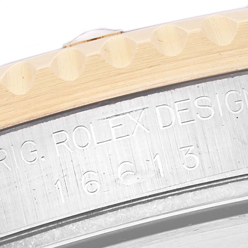 The image shows a close-up of the side engraving and edge of the bezel on a Rolex Submariner 16613 Men's Steel and Gold (two tone) Blue Dial 16613 Men's Steel and Gold (two tone) Blue Dial model.