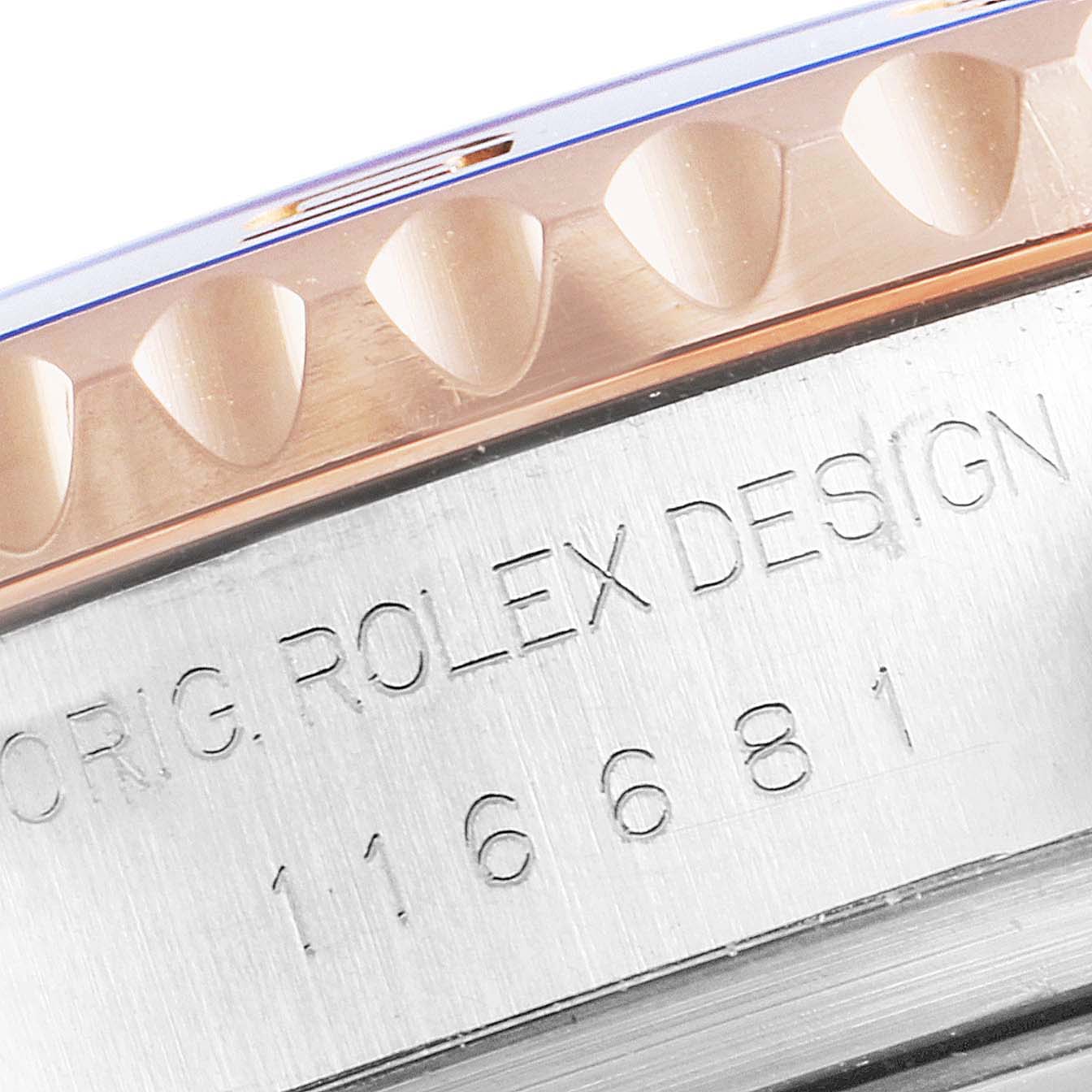 This close-up image of a Rolex Yacht-Master 116681 Men
s Steel and Gold (two tone) White Dial 116681 Men
s Steel and Gold (two tone) White Dial watch shows part of the bezel and the case with the engraving "ORIG. ROLEX DESIGN 116681".