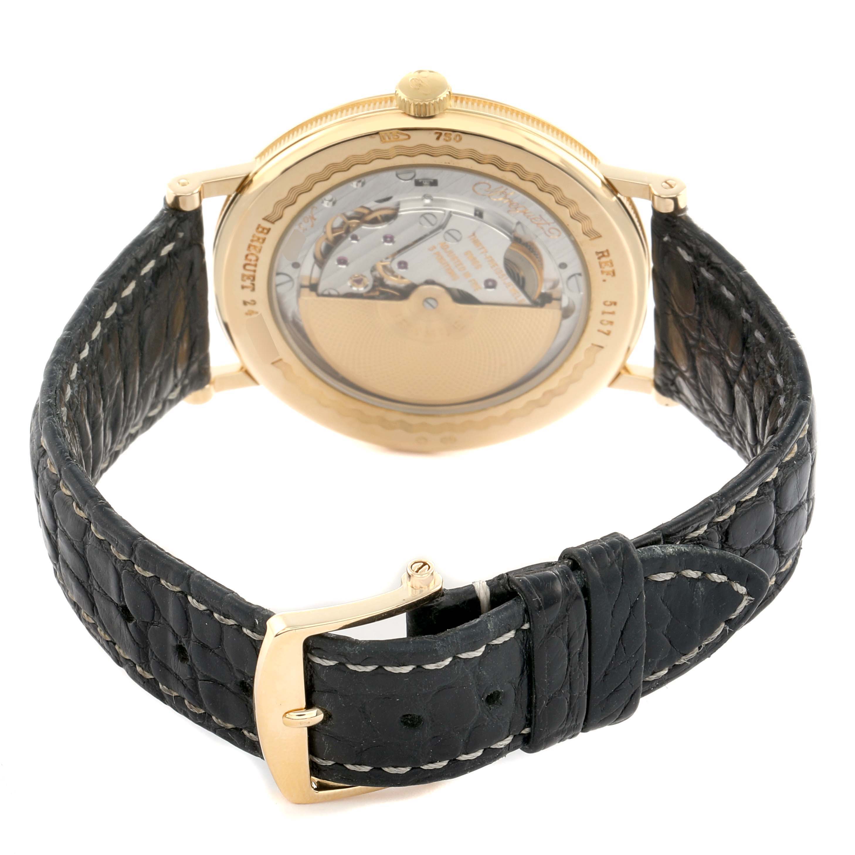 The image shows the back view of a Breguet Classique 5157BA Men's Yellow Gold Silver Dial watch, highlighting its movement and leather strap.