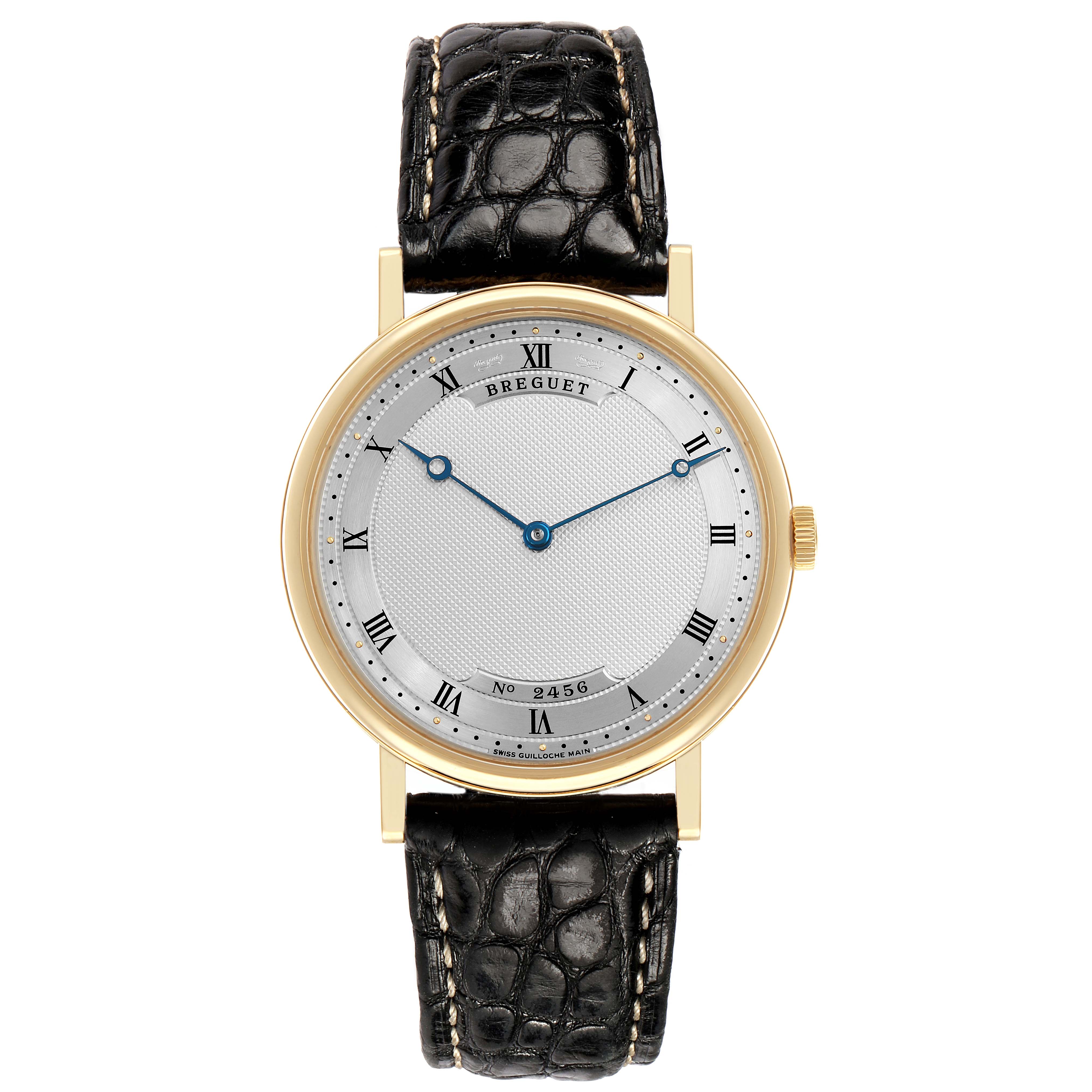 The Breguet Classique 5157BA Men's Yellow Gold Silver Dial watch is shown from a front angle, highlighting its dial, hands, and leather strap.