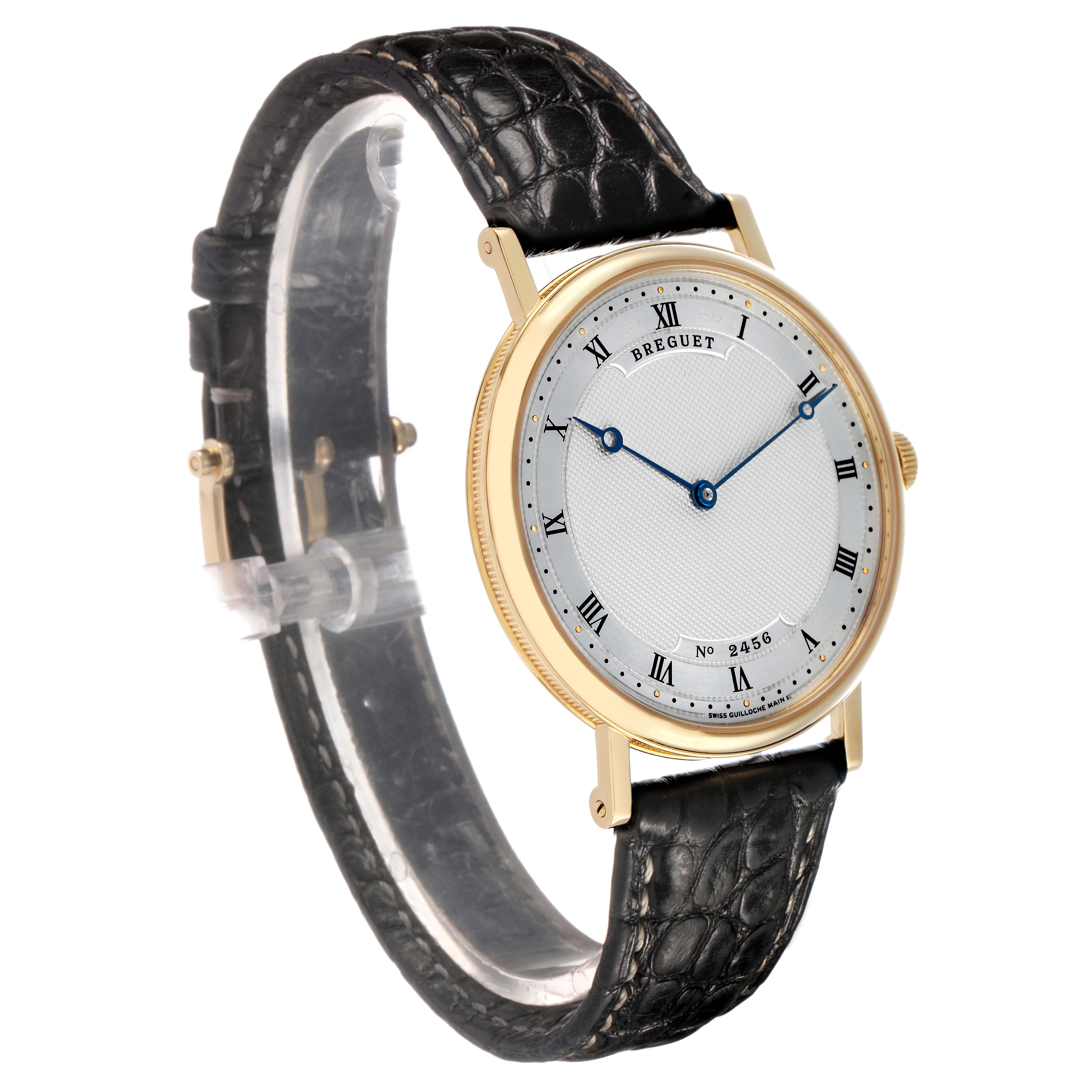 The Breguet Classique 5157BA Men's Yellow Gold Silver Dial watch is shown at a three-quarter angle, displaying its face, lugs, and leather strap.