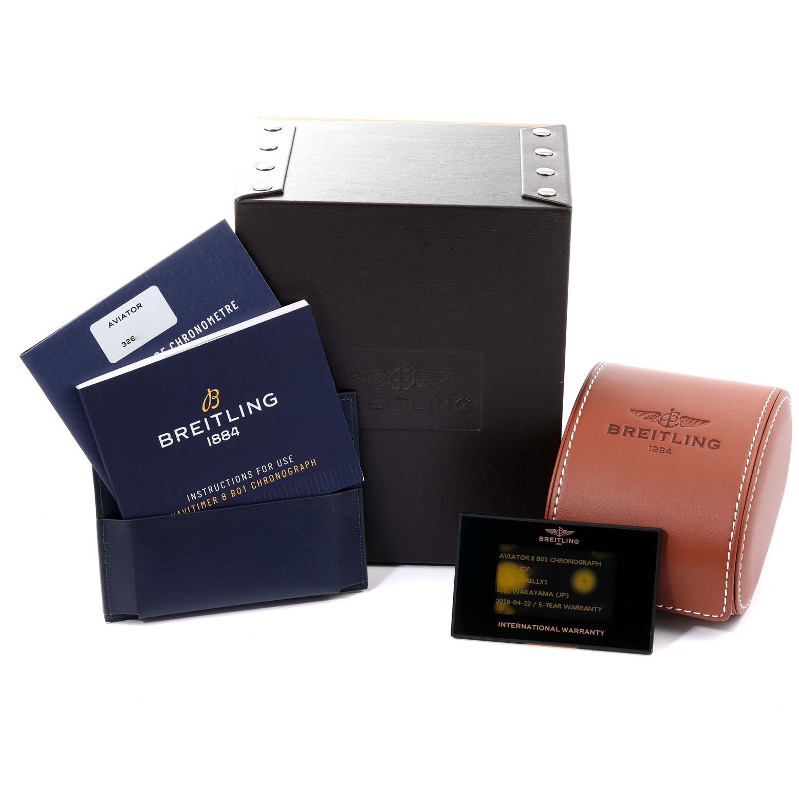 The image shows the accessories for the Breitling Navitimer model, including manuals, a warranty card, a watch case, and a box.