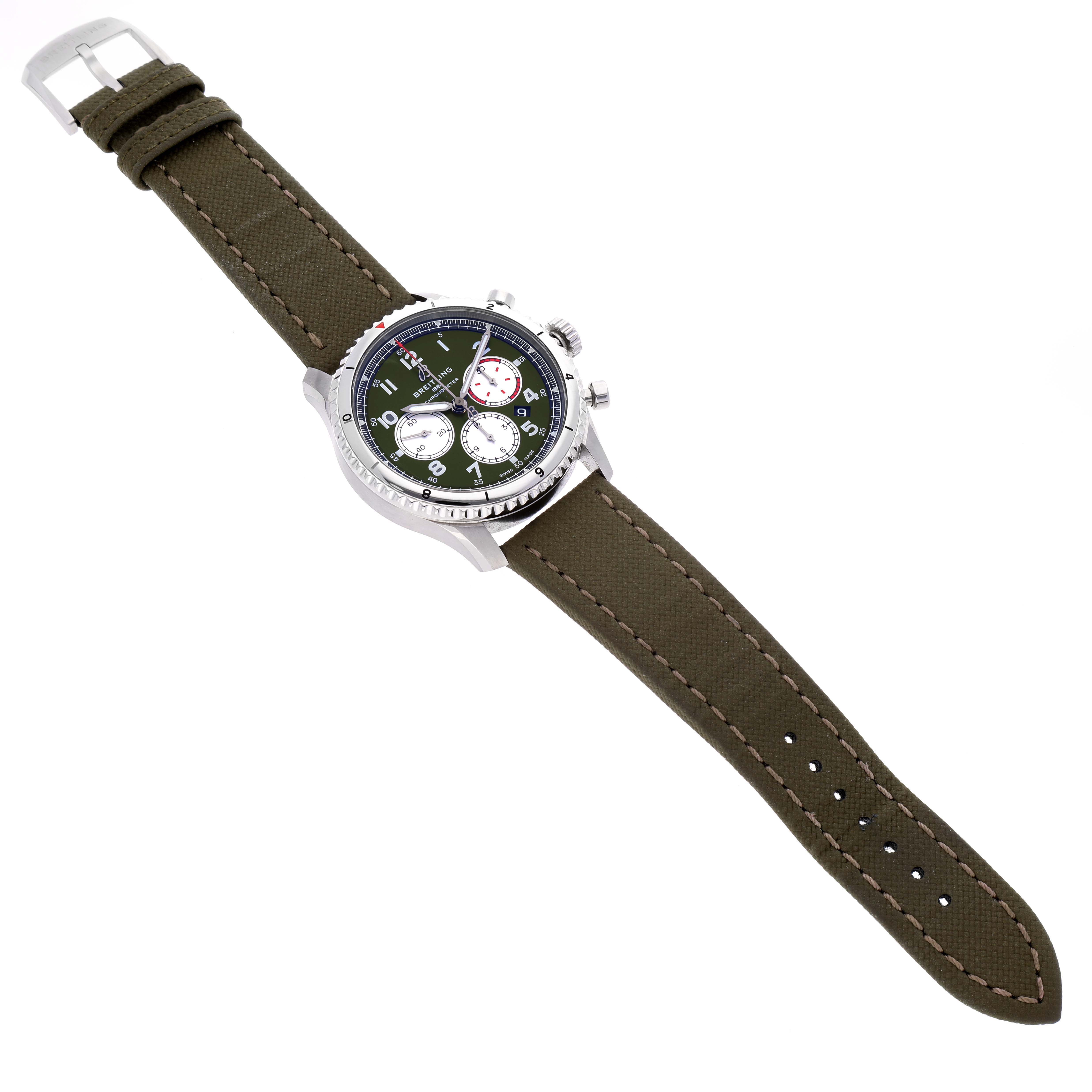 The Breitling Navitimer is shown from an overhead angle, displaying the face, bezel, pushers, and green strap.
