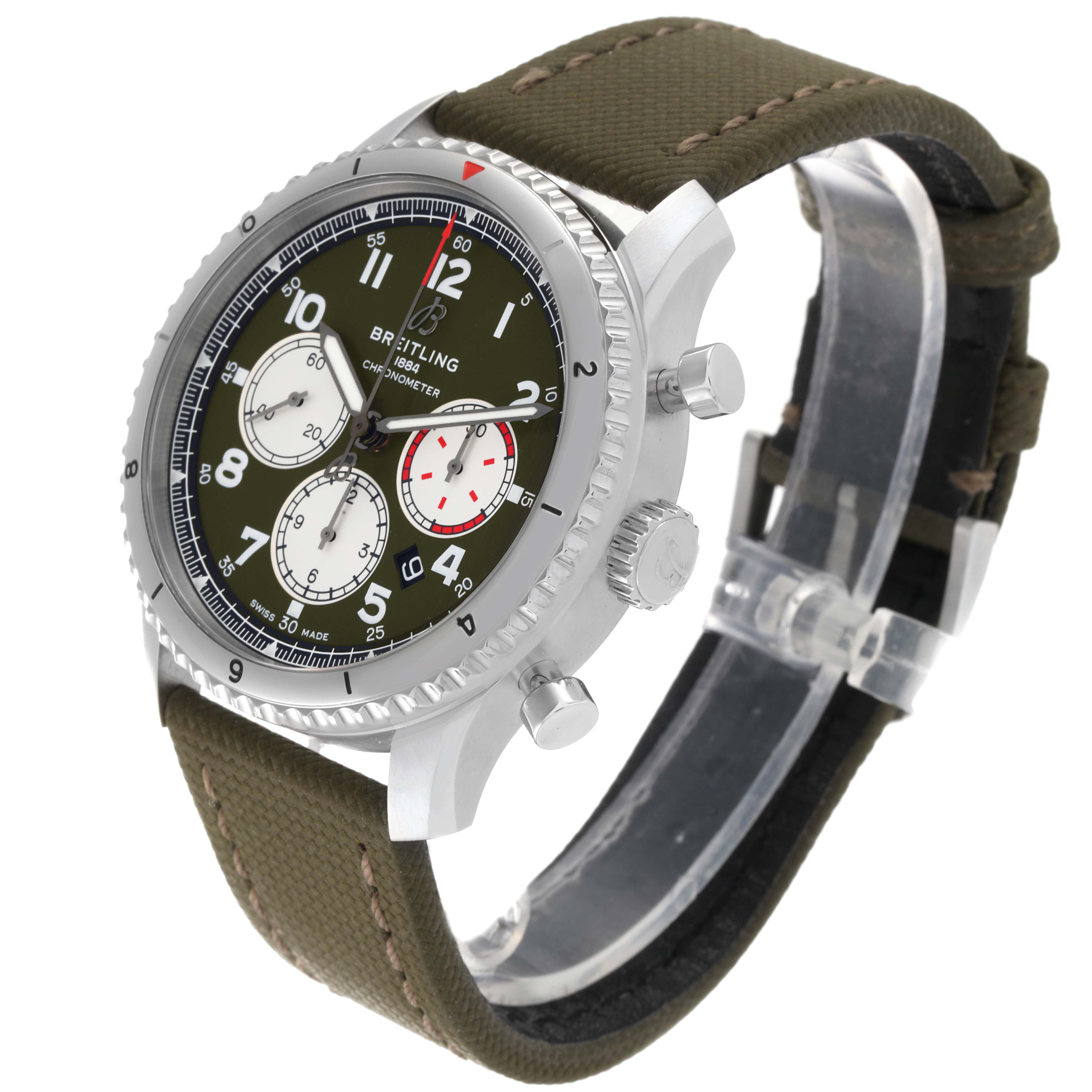 The Breitling Navitimer watch is shown at an oblique angle, displaying its dial, bezel, chronograph buttons, and fabric strap.