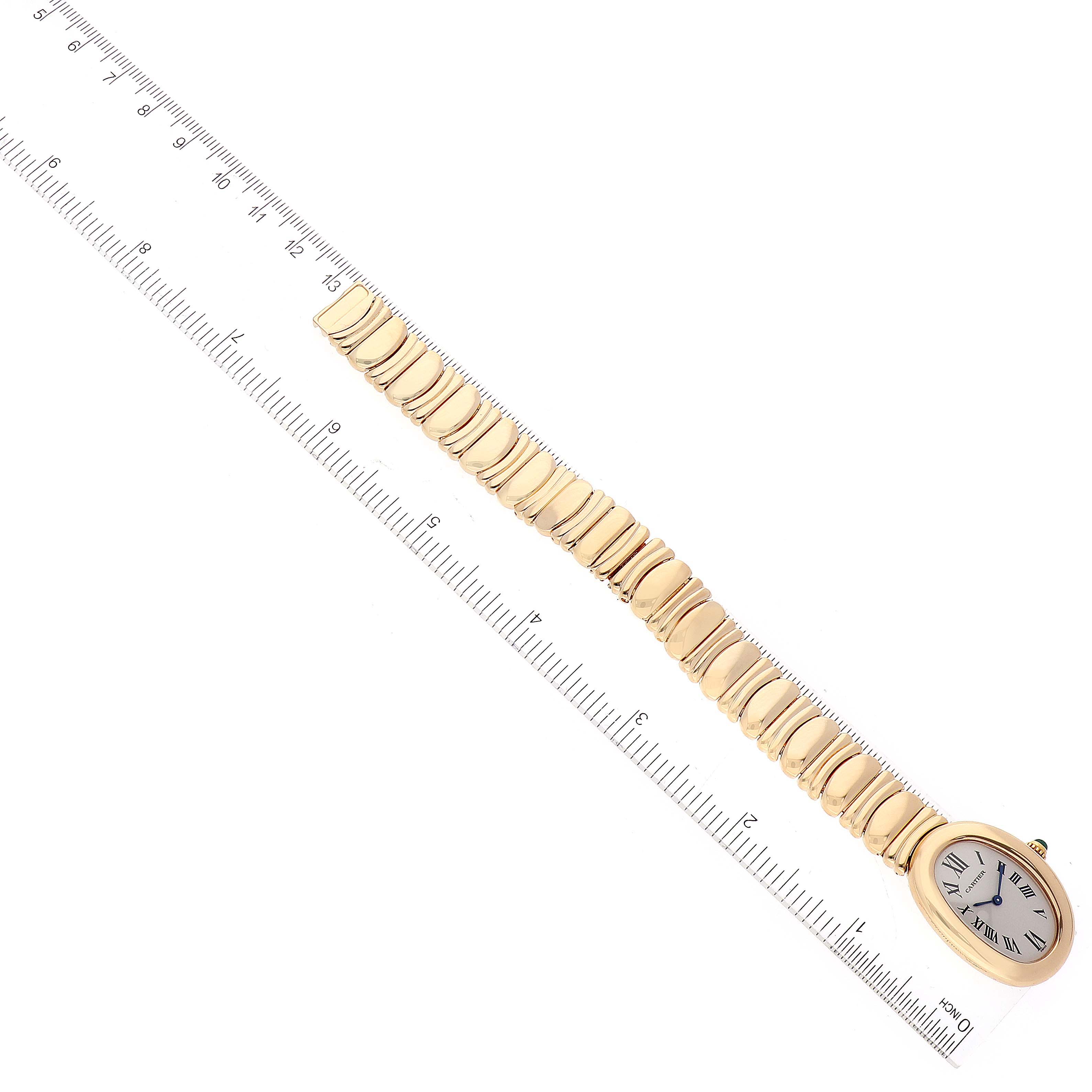The image shows a Cartier Baignoire 1954 Women's Yellow Gold Silver Dial 1954 Women's Yellow Gold Silver Dial watch lying flat, displaying the gold bracelet and oval watch face, measured against a ruler.