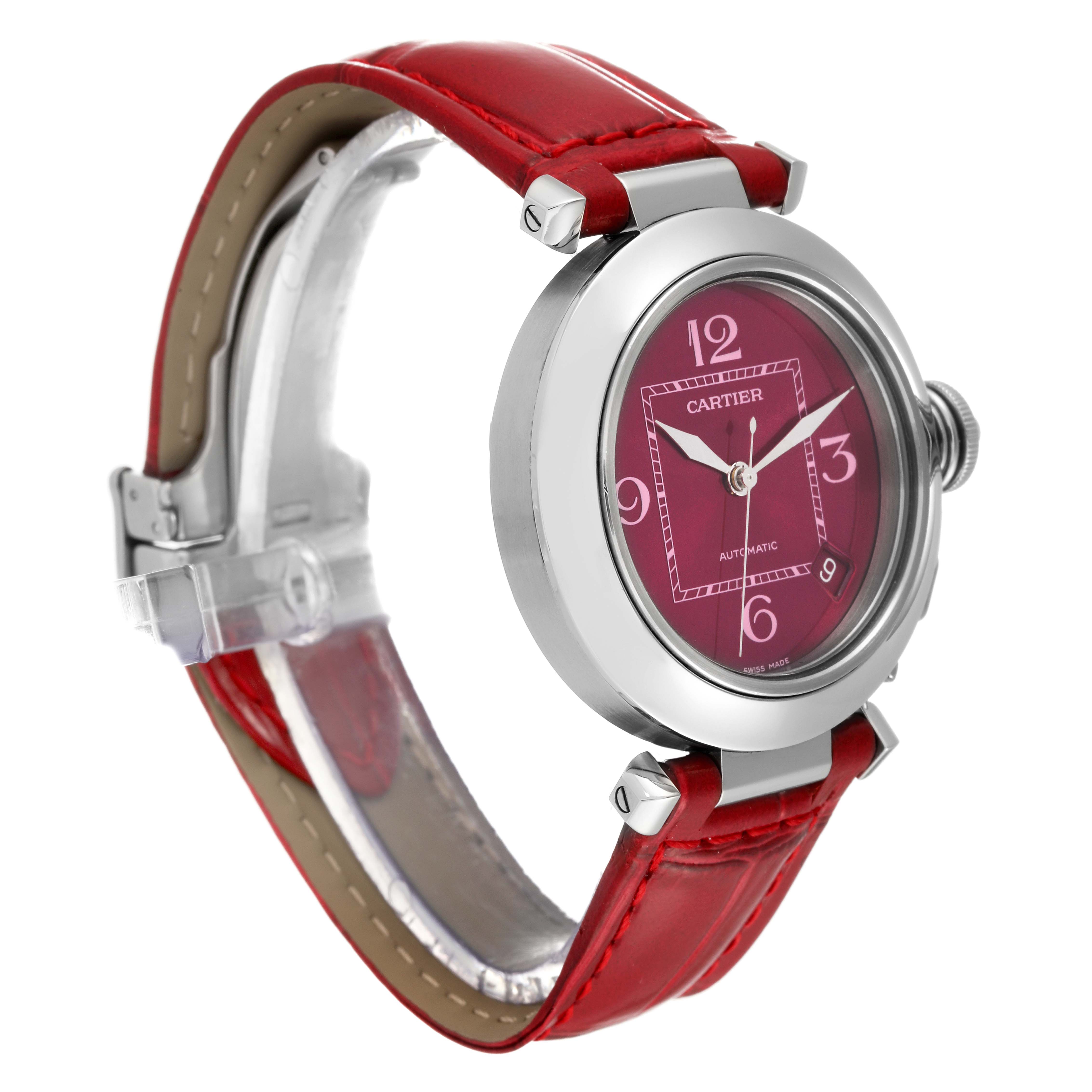 The image shows a side angle of the Cartier Pasha W3108299 Women's Stainless Steel Pink Dial W3108299 Women's Stainless Steel Pink Dial watch with a red strap and a round red dial.