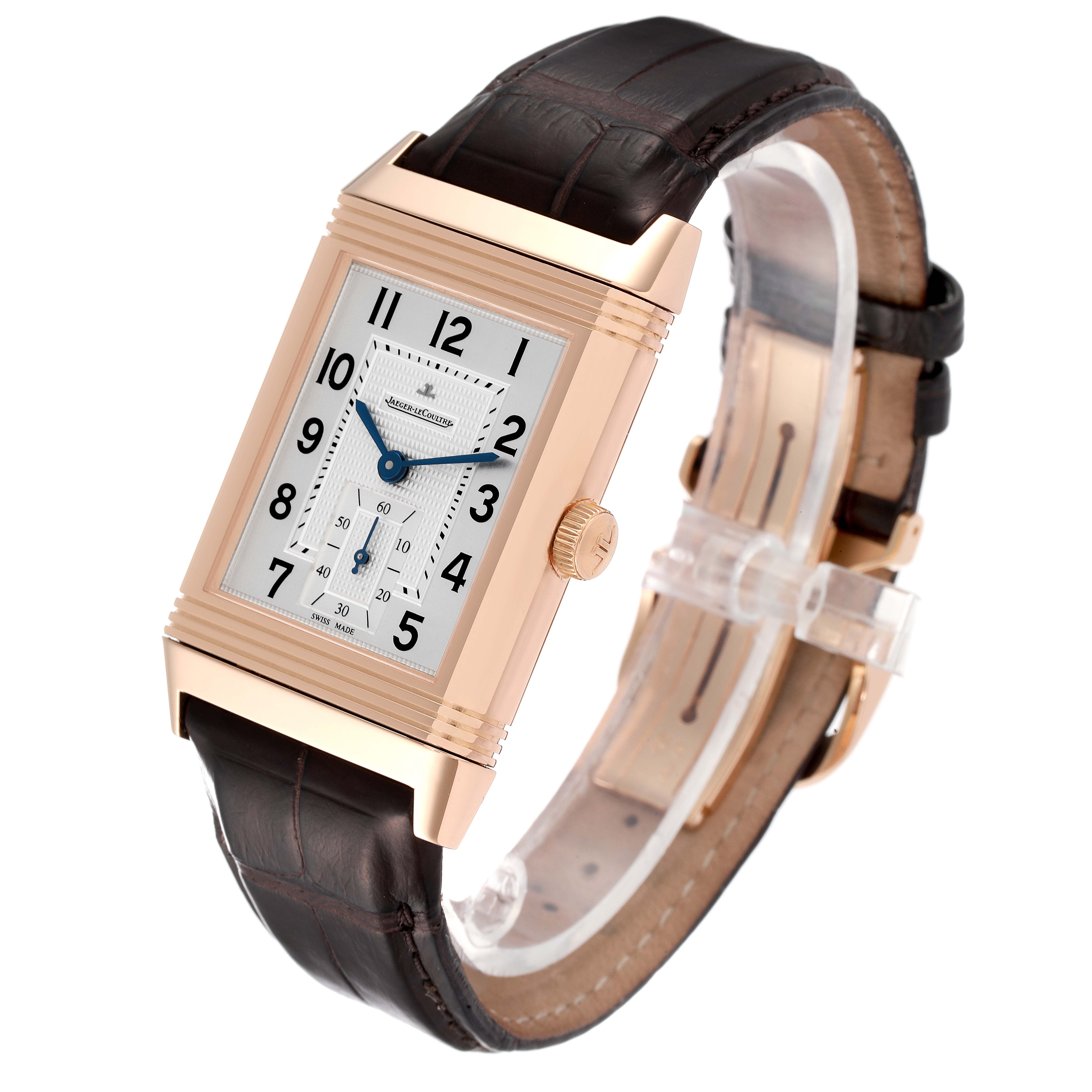 This Jaeger LeCoultre Reverso Q3732420 Men's Rose Gold Silver Dial Q3732420 Men's Rose Gold Silver Dial watch is shown at an angle displaying its rectangular dial, gold case, crown, and brown leather strap.