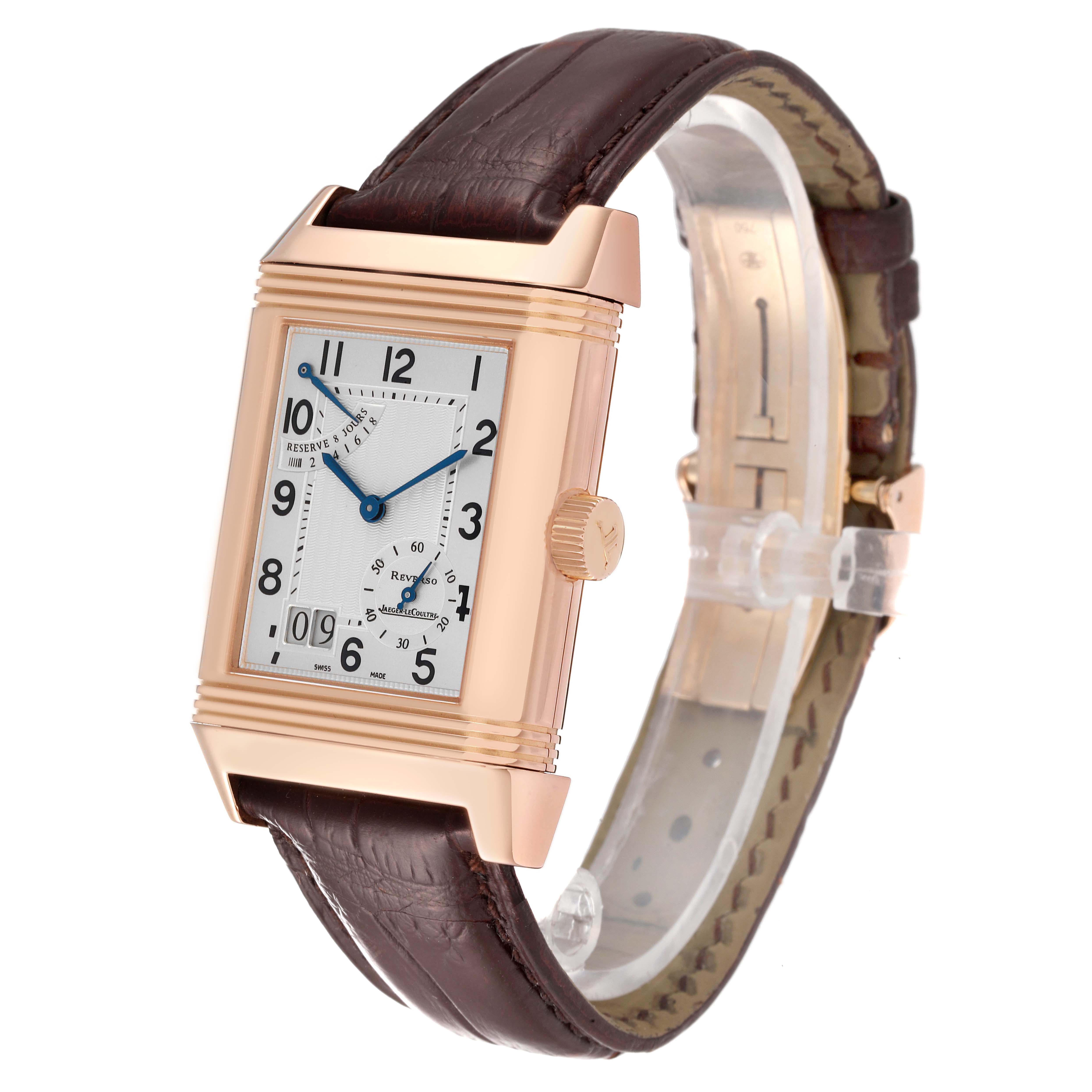 The Jaeger-LeCoultre Reverso watch is shown at a three-quarter angle, highlighting its face, rectangular case, crown, and leather strap.