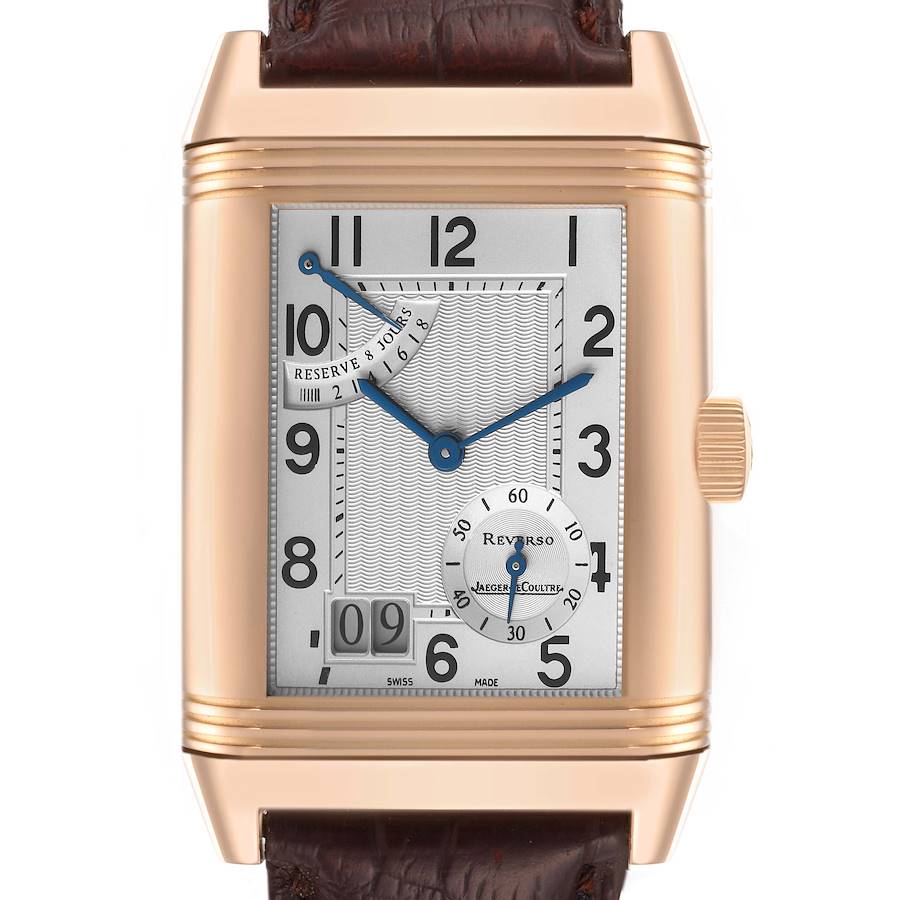 The Jaeger-LeCoultre Reverso watch is shown from a front angle, displaying its dial, hands, date, and leather strap.