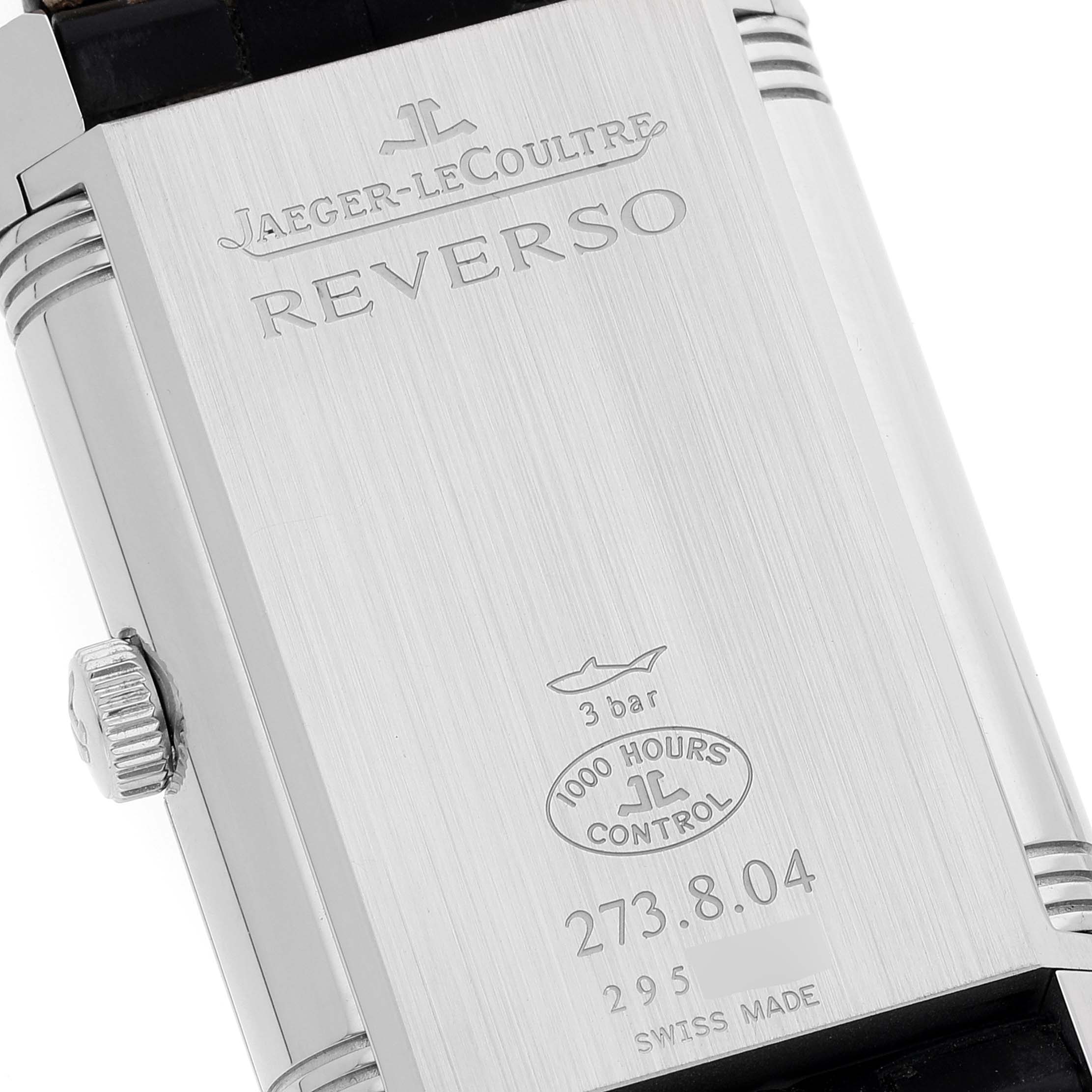 The image shows the back case of a Jaeger-LeCoultre Reverso watch, displaying the brand's engraving and model details.