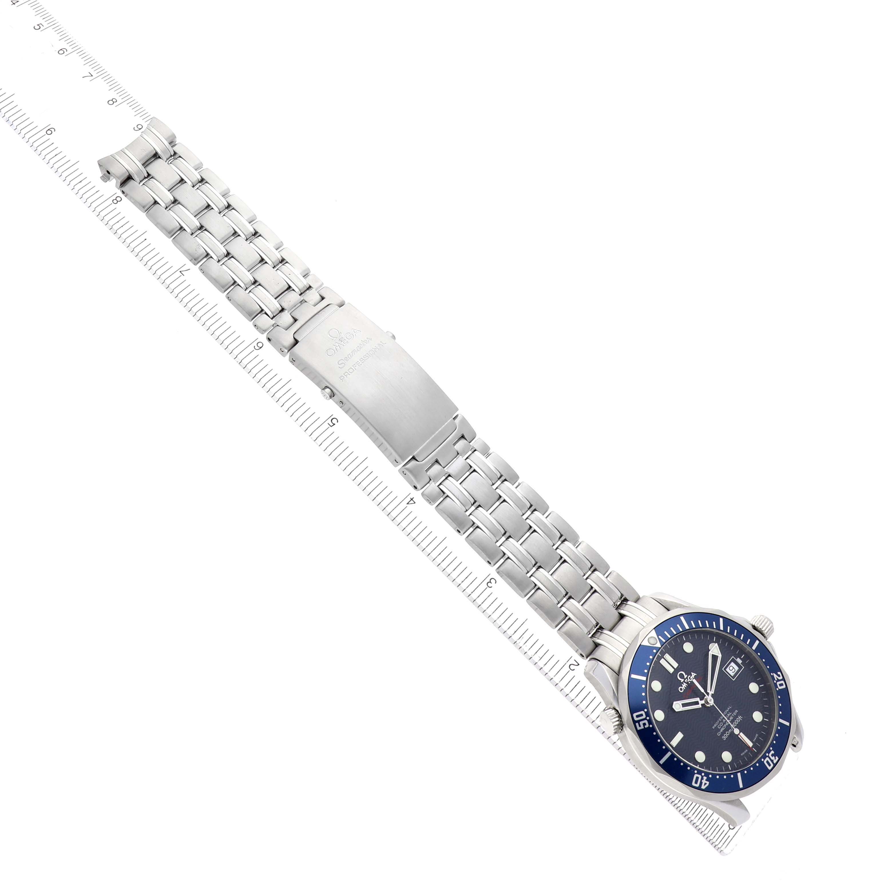 The Omega Seamaster 2220.80.00 Men's Stainless Steel Blue Dial watch is shown at a top angle with a full view of the stainless steel bracelet and clasp, alongside a measuring ruler.