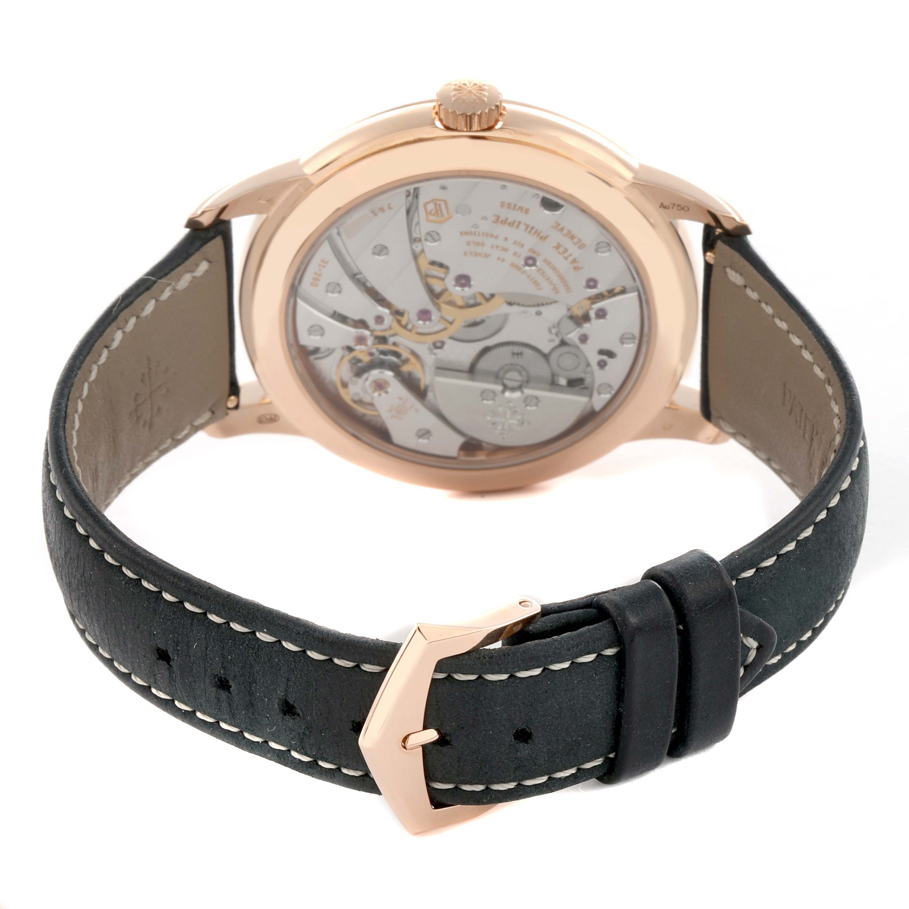 The Patek Philippe Calatrava 5224R-001 Men's Rose Gold Blue Dial watch is shown from the back, highlighting its mechanism, rose gold case, and leather strap.