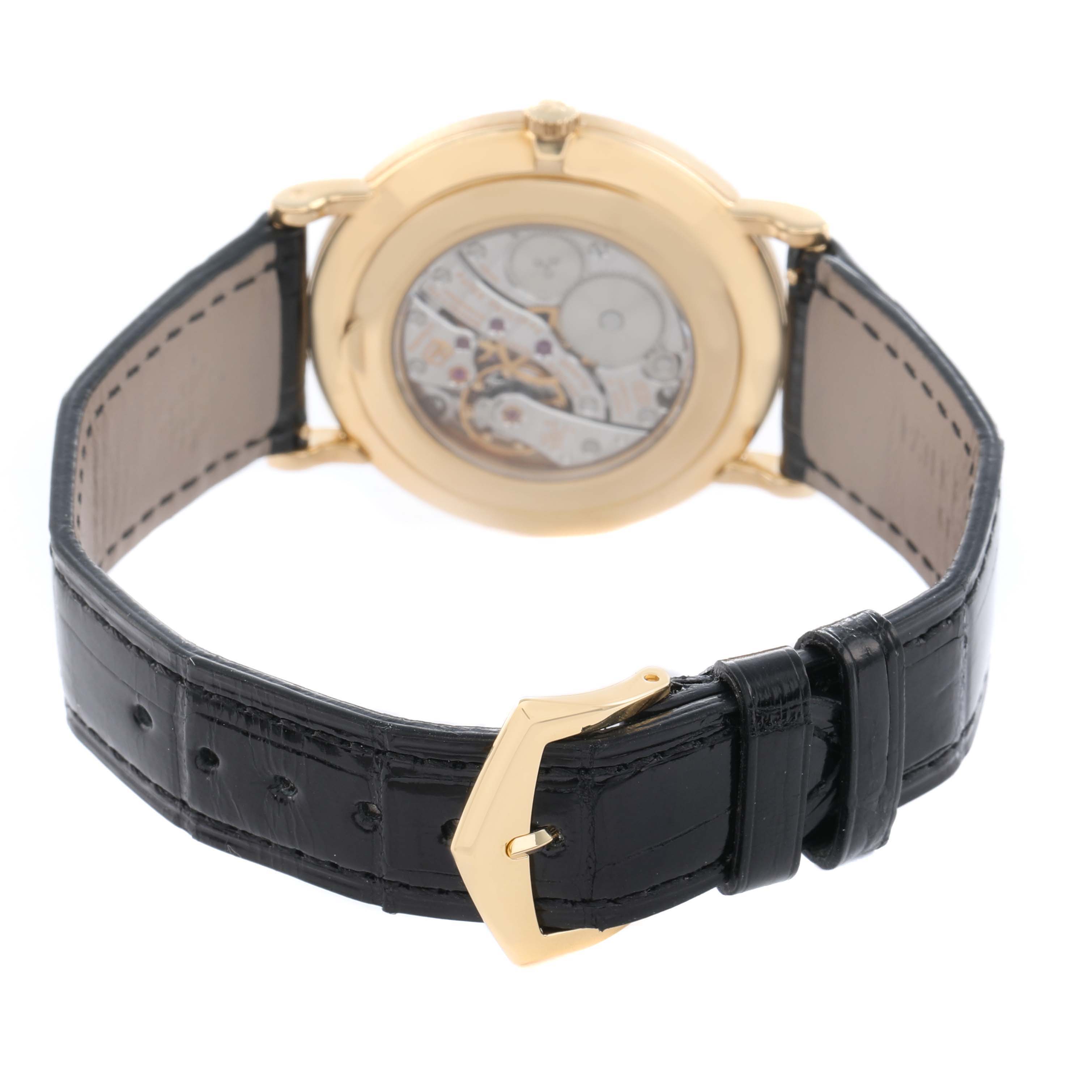 The image shows the back of a Patek Philippe Calatrava 5119 Men
s Yellow Gold White Dial, highlighting its movement through a transparent case back and a black leather strap with a gold buckle.