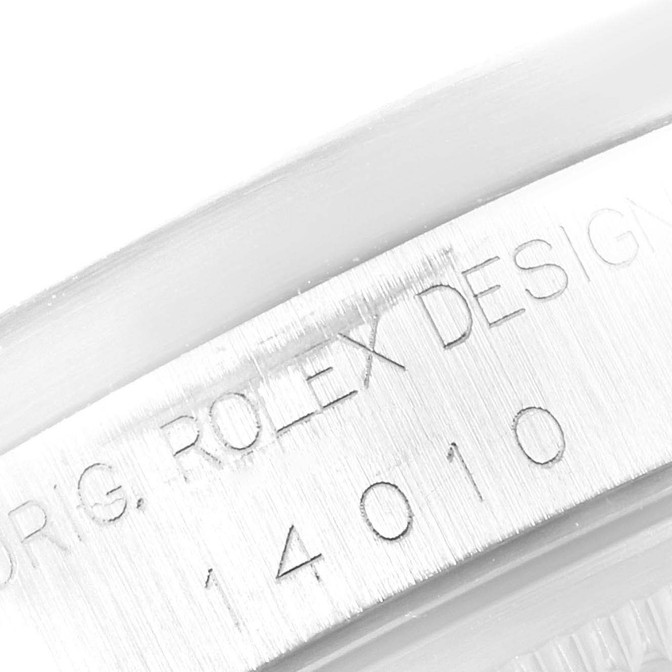This image shows a close-up of the engraved serial number and "Rolex Design" text on the casing of a Rolex Air-King 14010 Men's Stainless Steel Silver Dial 14010 Men's Stainless Steel Silver Dial watch.