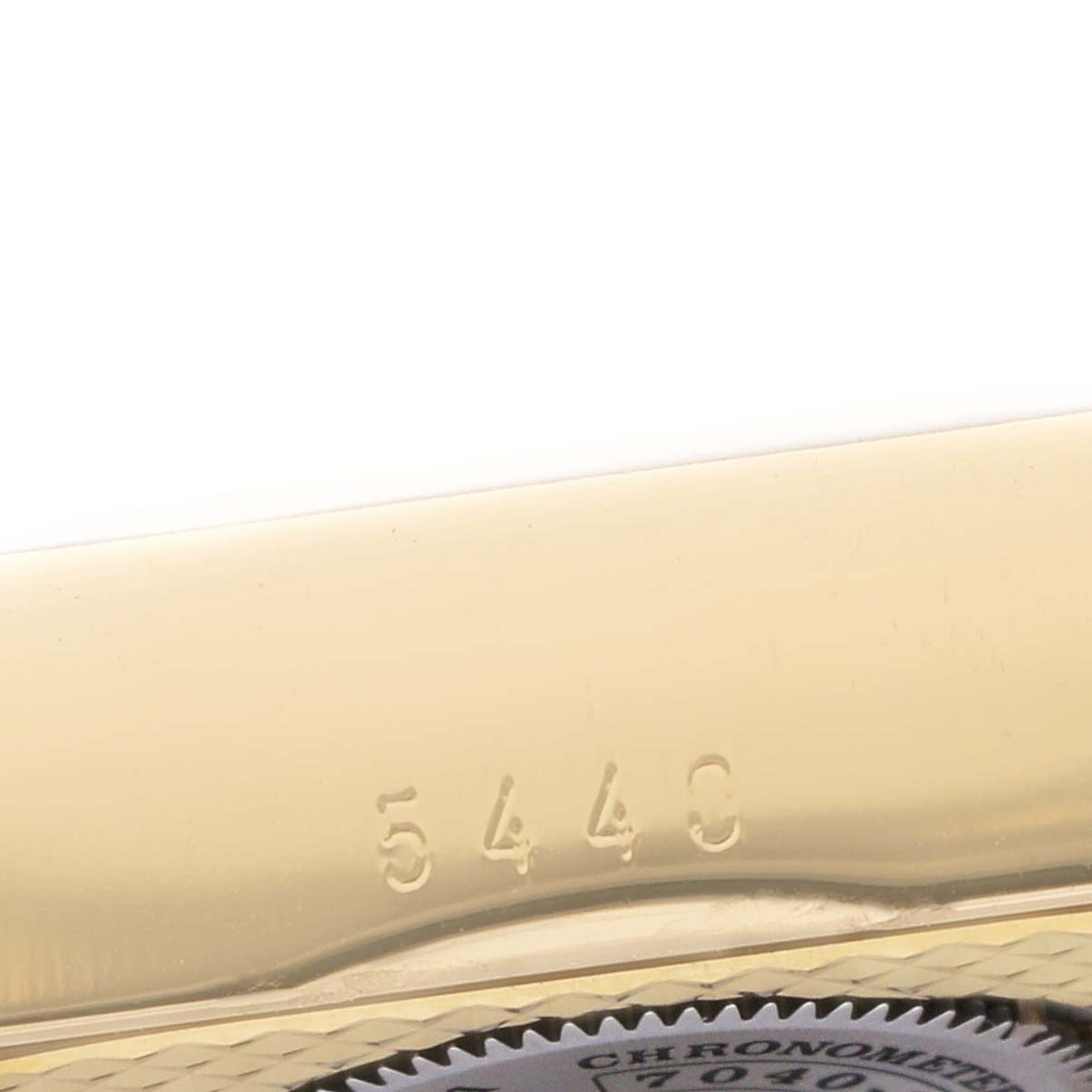 The image shows a close-up of the gold case and engraved serial number on the Rolex Cellini 5440 Men's Yellow Gold Champagne Dial watch.