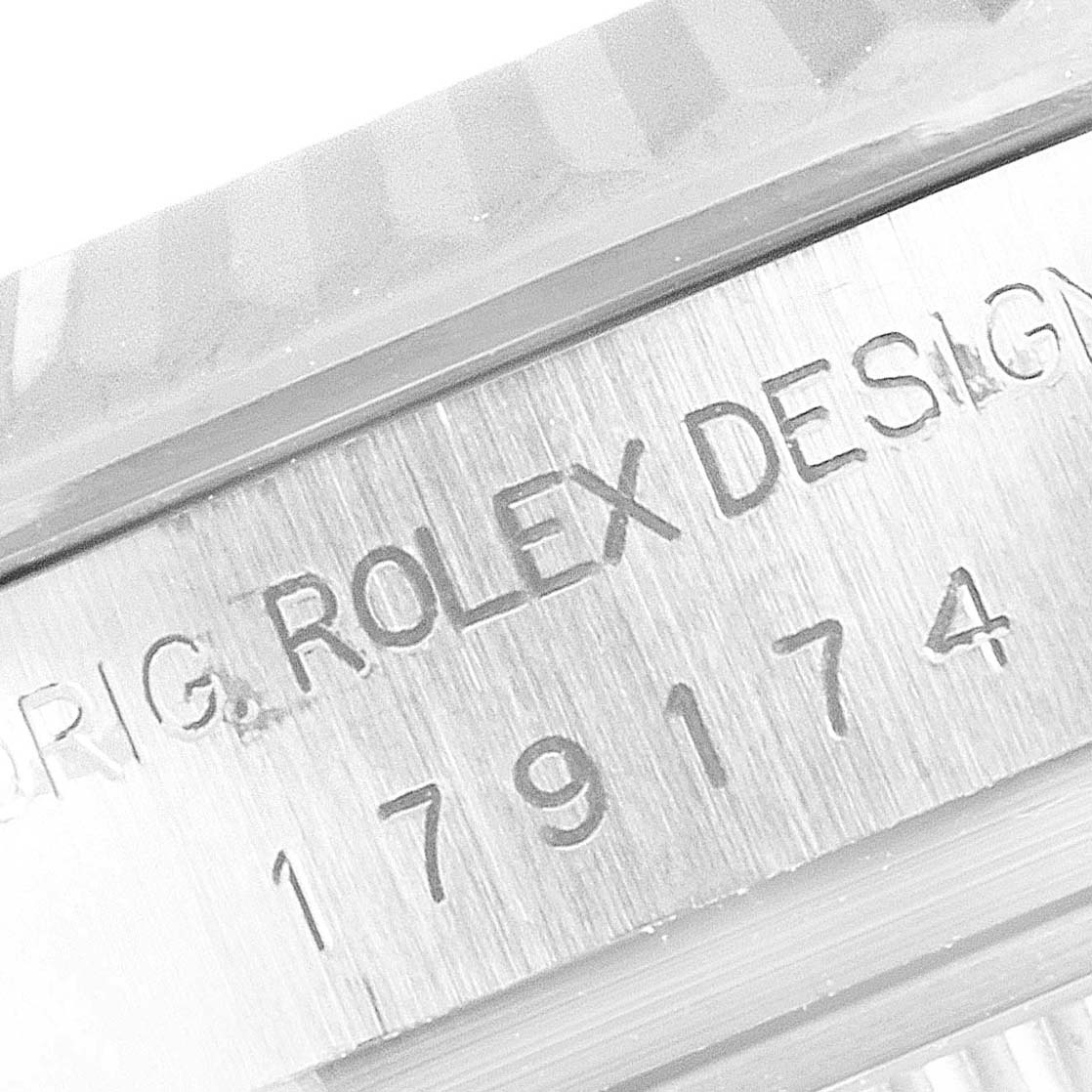 This image shows a close-up of a Rolex Datejust 179174 Women's Steel and Gold (two tone) Silver Dial 179174 Women's Steel and Gold (two tone) Silver Dial model's case, featuring the serial number and design inscription.