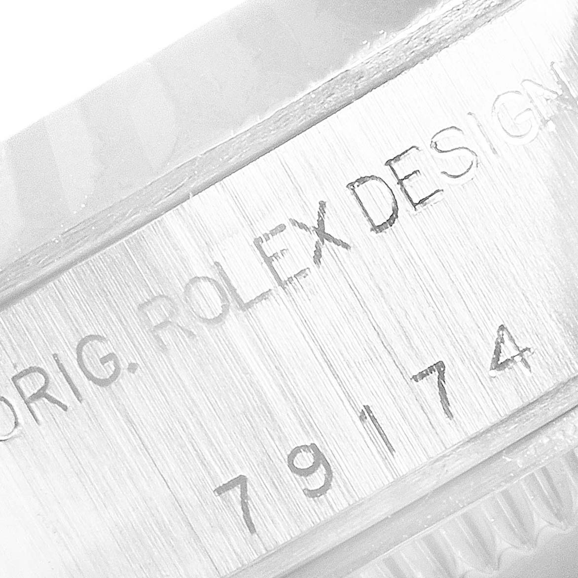 This image shows a close-up of the engraving on the case of a Rolex Datejust 79174 Women's Stainless Steel Pink Dial 79174 Women's Stainless Steel Pink Dial watch.