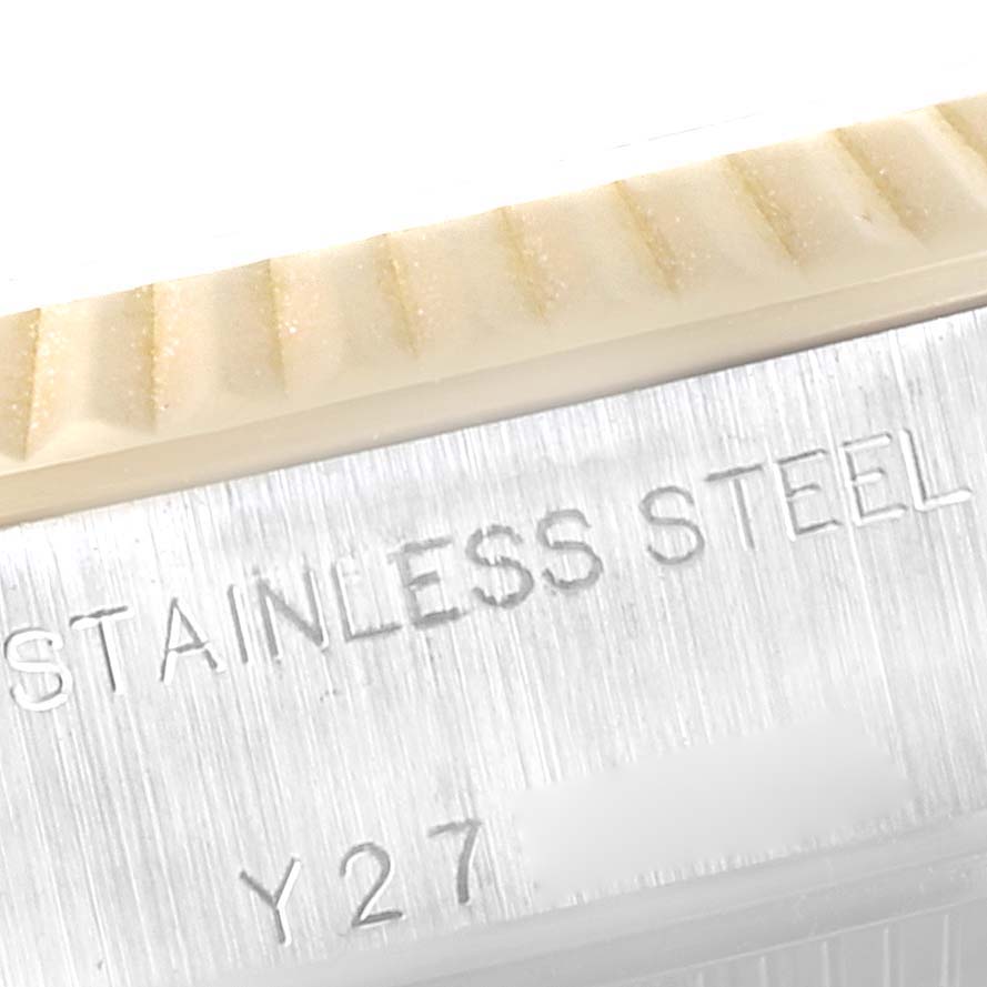 The image shows a close-up of the fluted bezel and inscription on the side of a Rolex Datejust 79173 Women's Steel and Gold (two tone) White Dial 79173 Women's Steel and Gold (two tone) White Dial watch, indicating "STAINLESS STEEL" and part of the serial number.