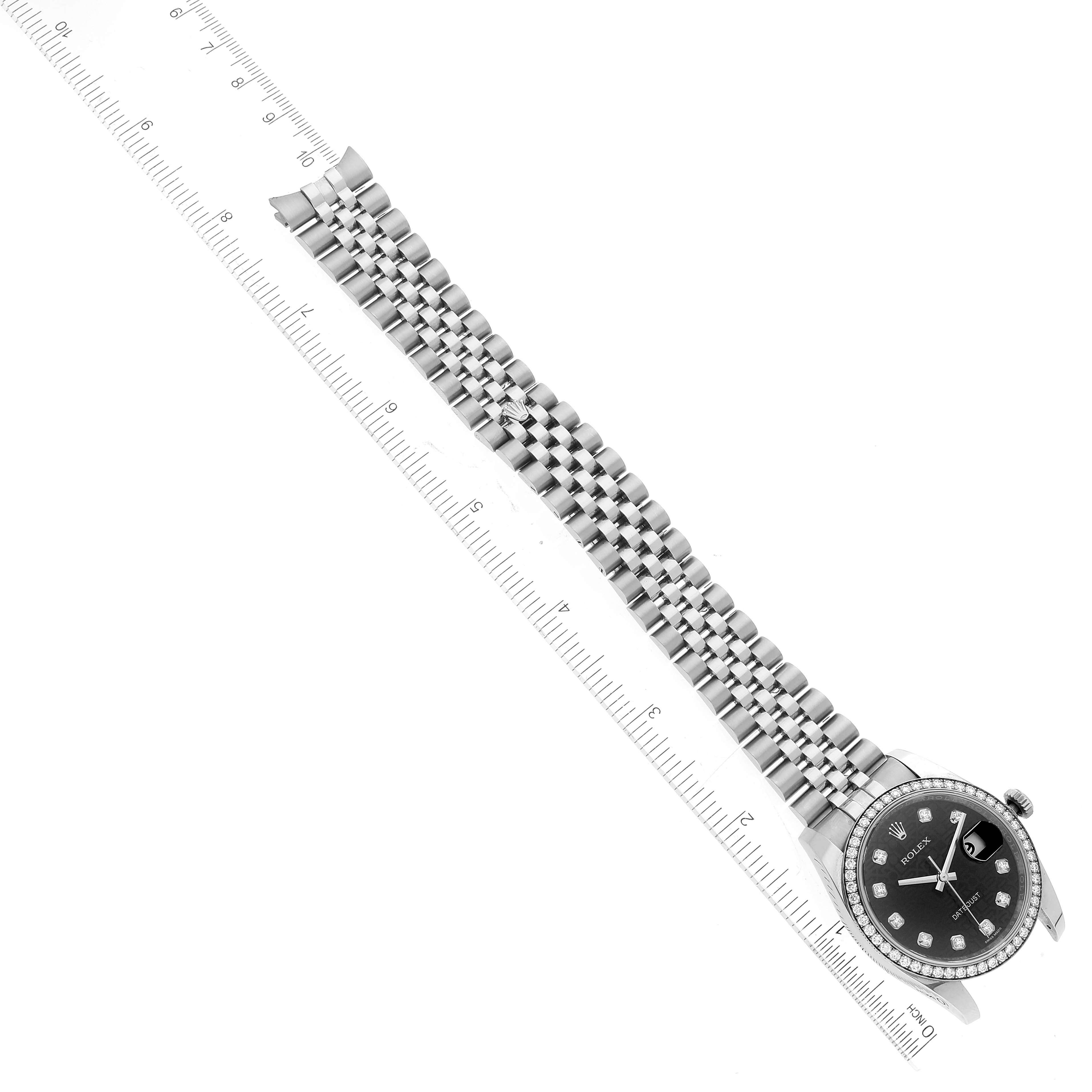 This Rolex Datejust 116244 Men's Stainless Steel Black Dial 116244 Men's Stainless Steel Black Dial watch is shown from an overhead angle, displaying its bracelet, dial, and part of a ruler for scale.
