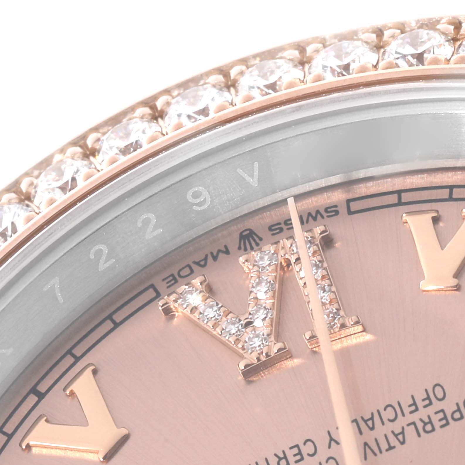 The image shows a close-up of the bezel, part of the dial, and diamond-set Roman numerals of a Rolex Datejust 126281 Men's Steel and Gold (two tone) Pink Dial 126281 Men's Steel and Gold (two tone) Pink Dial watch.