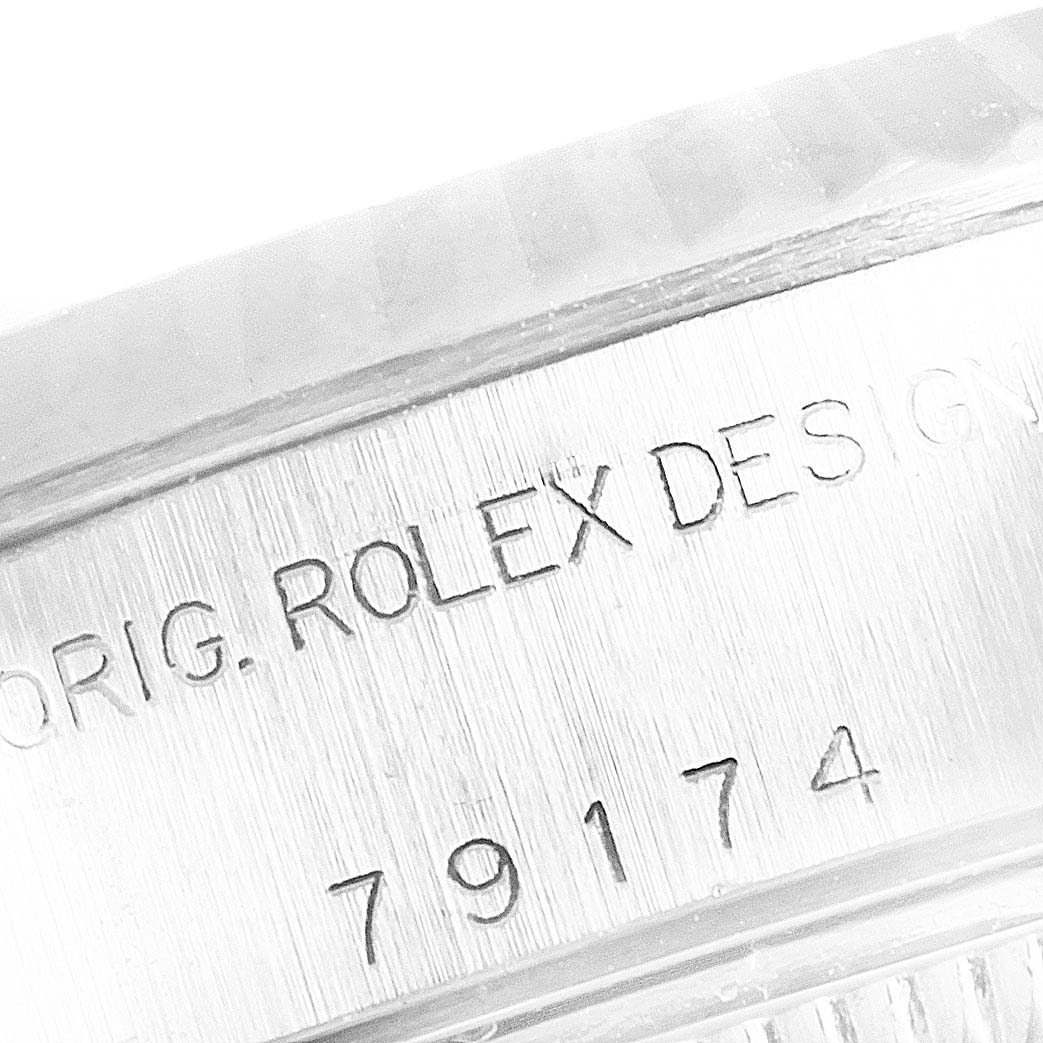 The image shows a close-up of the side of a Rolex Datejust 79174 Women's Stainless Steel White Dial 79174 Women's Stainless Steel White Dial model case, highlighting the engraved model number and "Rolex Design" inscription.