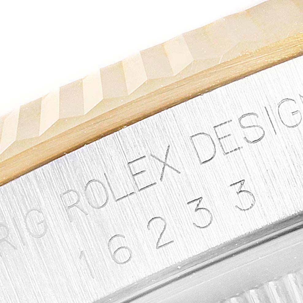 The image shows a close-up of the fluted bezel and engraved model number of a Rolex Datejust 16233 Men's Steel and Gold (two tone) Champagne Dial 16233 Men's Steel and Gold (two tone) Champagne Dial watch.
