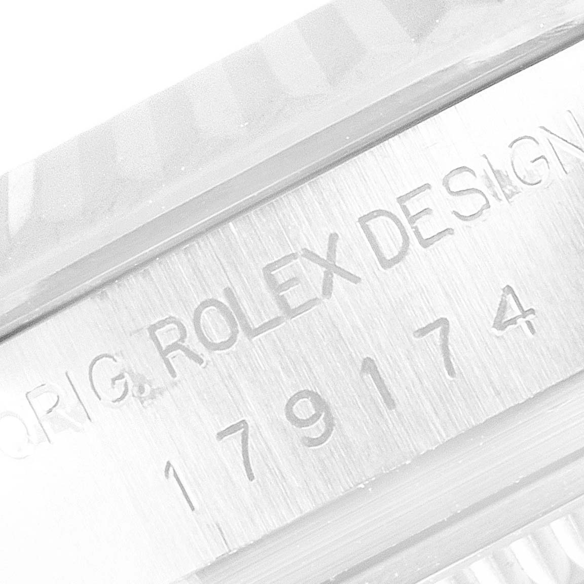 This close-up shows the engraved serial number and part of the fluted bezel of the Rolex Datejust 179174 Women's Stainless Steel Mother of Pearl Dial 179174 Women's Stainless Steel Mother of Pearl Dial watch.