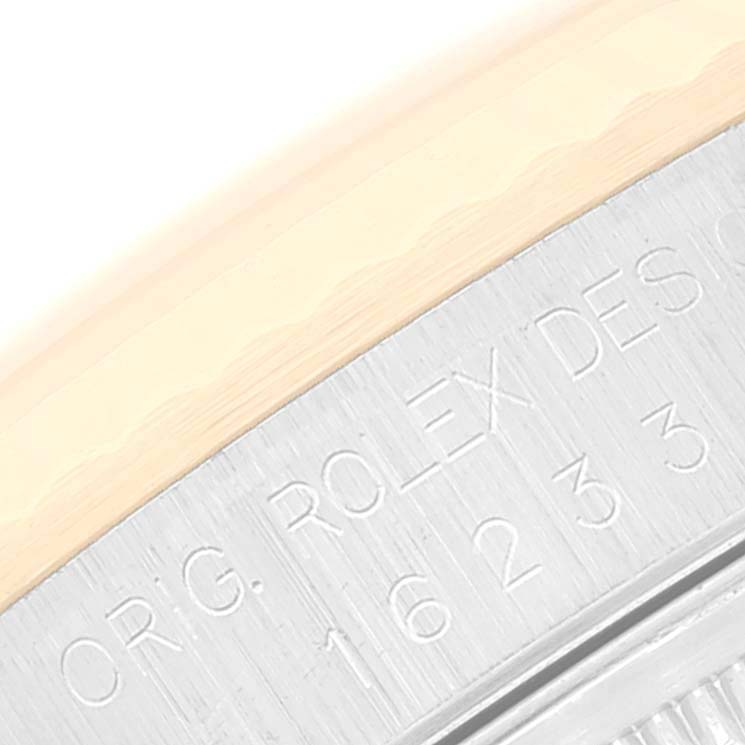 The image shows a close-up of the Rolex Datejust 16233 Men's Steel and Gold (two tone) White Dial 16233 Men's Steel and Gold (two tone) White Dial model’s engraved case side with part of the bezel.