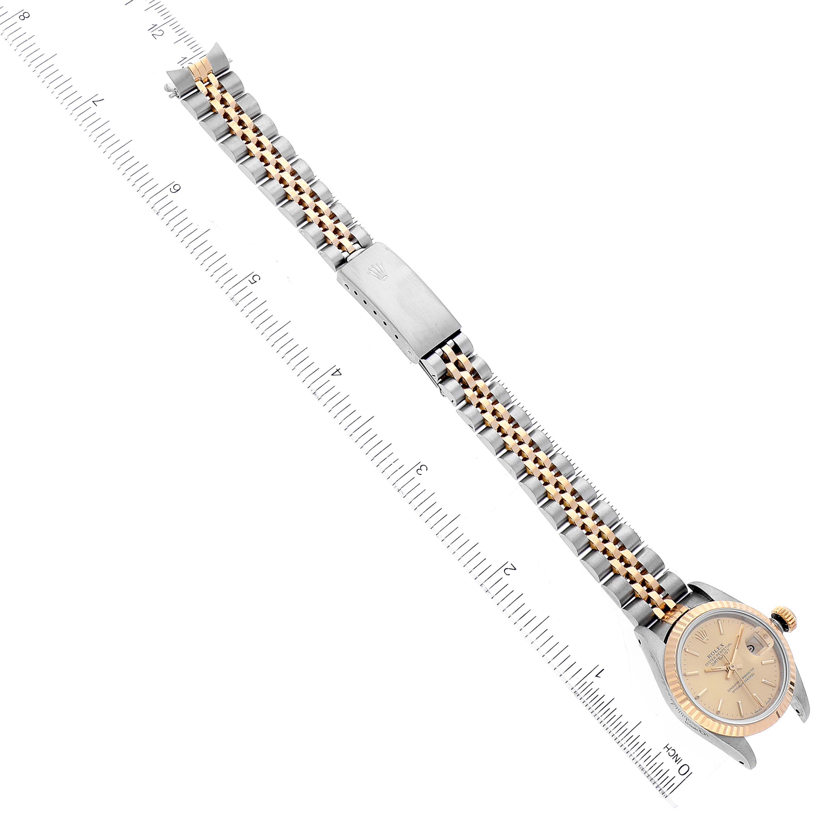 This image shows a Rolex Datejust 69173 Women's Steel and Gold (two tone) Champagne Dial 69173 Women's Steel and Gold (two tone) Champagne Dial watch placed flat with a focus on its bracelet and dial, measured against a ruler.