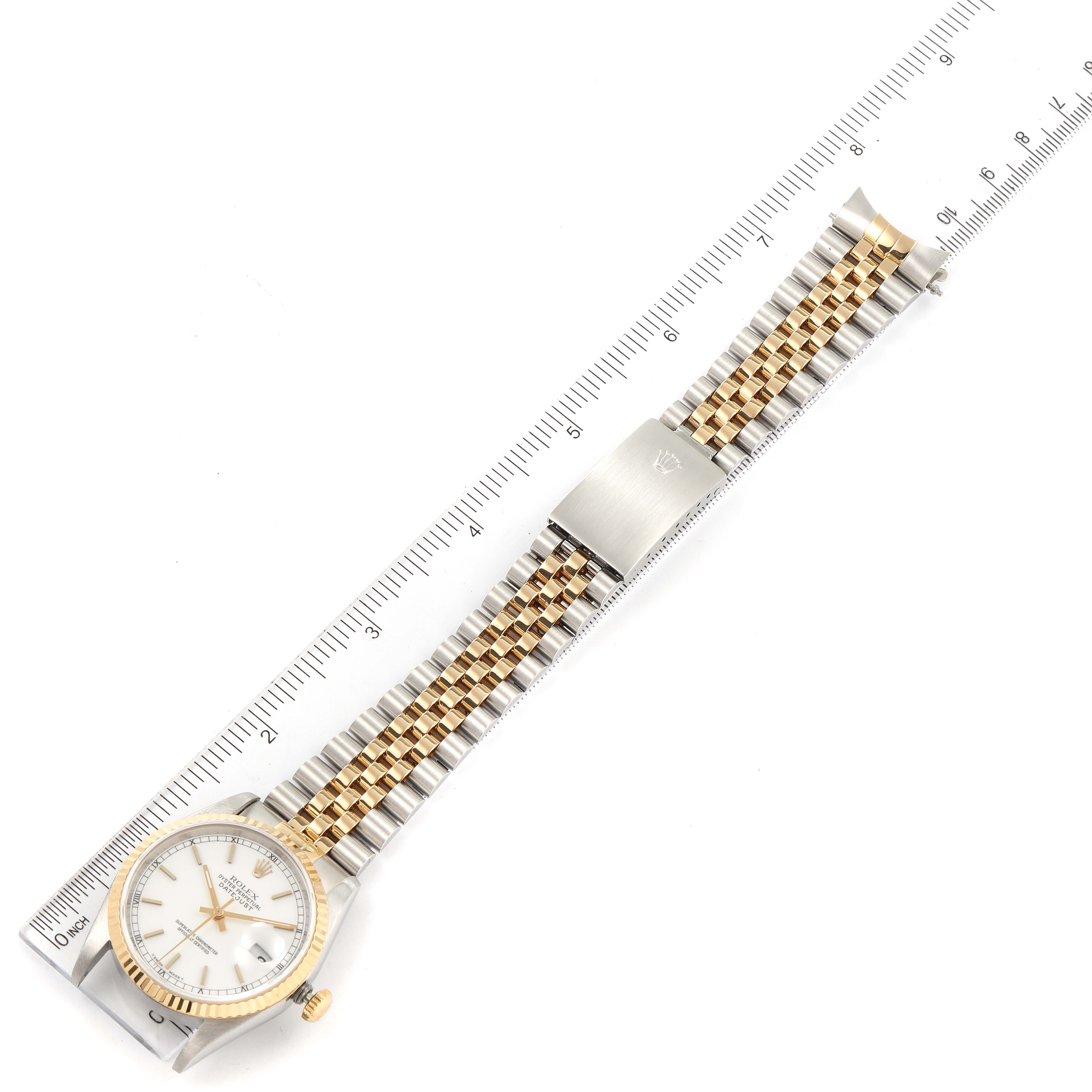This image shows a Rolex Datejust 16233 Men's Steel and Gold (two tone) White Dial 16233 Men's Steel and Gold (two tone) White Dial watch lying flat, displaying its face, bezel, bracelet, and clasp, aligned with a measuring ruler.