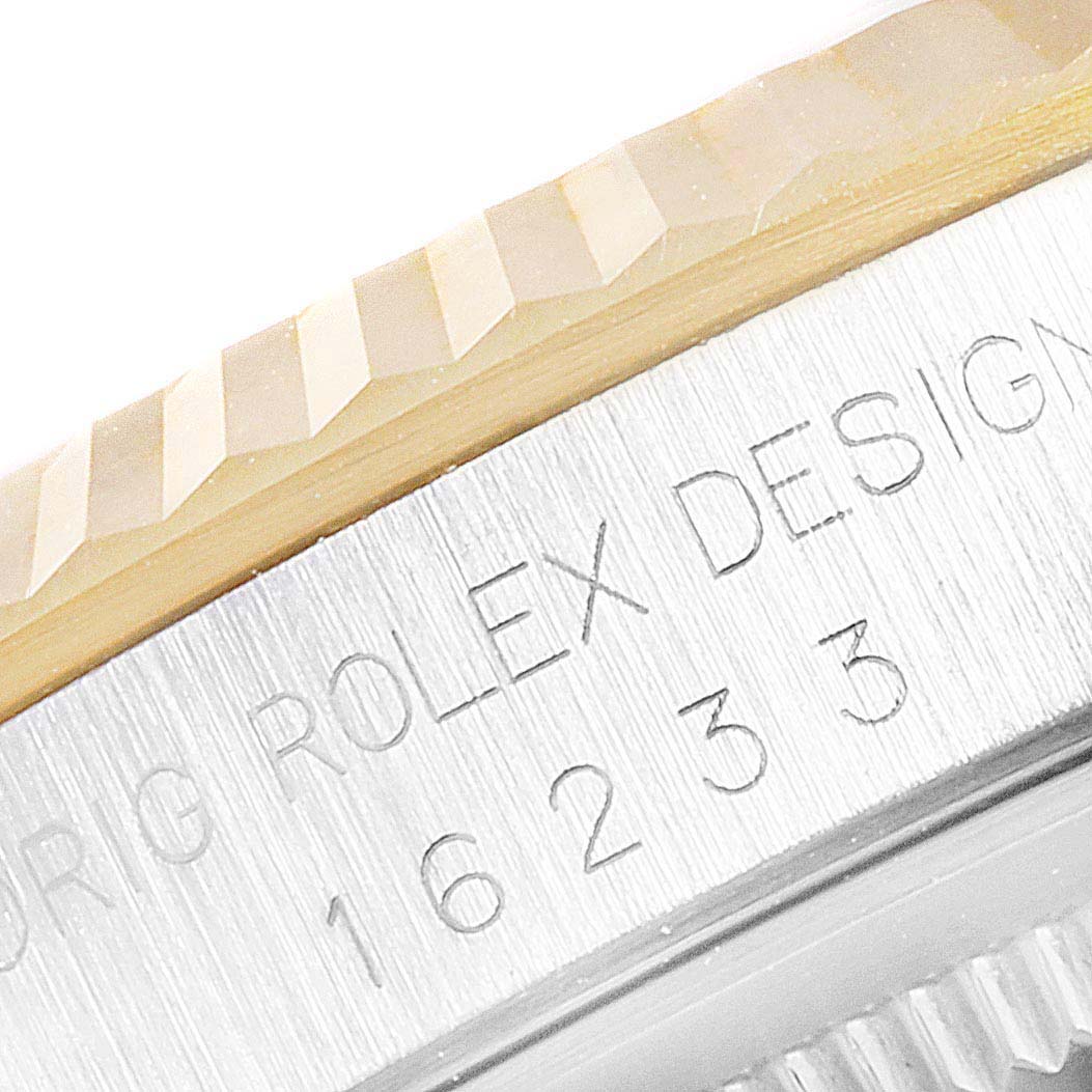 The image shows a close-up of the fluted bezel and engraved side of a Rolex Datejust 16233 Men's Steel and Gold (two tone) White Dial 16233 Men's Steel and Gold (two tone) White Dial model, indicating the model number 16233.