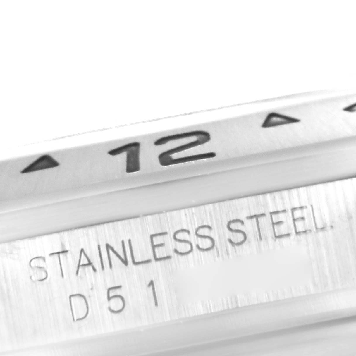 This close-up image of a Rolex Explorer 16570 Men
s Stainless Steel Black Dial 16570 Men
s Stainless Steel Black Dial watch shows part of the bezel and the inscription "STAINLESS STEEL" on the case.