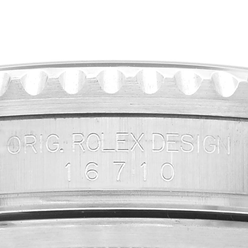 This image shows a close-up of the Rolex GMT-Master 16710 Men's Stainless Steel Black Dial 16710 Men's Stainless Steel Black Dial model 16710, focusing on the engraved serial and model number on its case side.