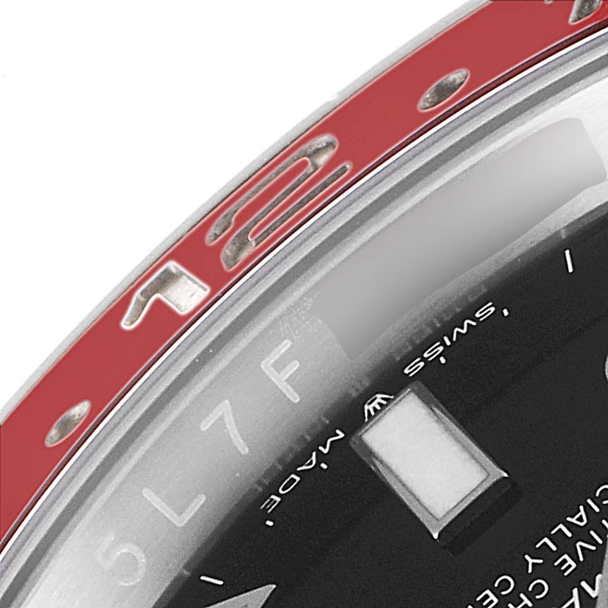 The image shows a close-up of the GMT-Master watch by Rolex, highlighting part of the red bezel and part of the dial.