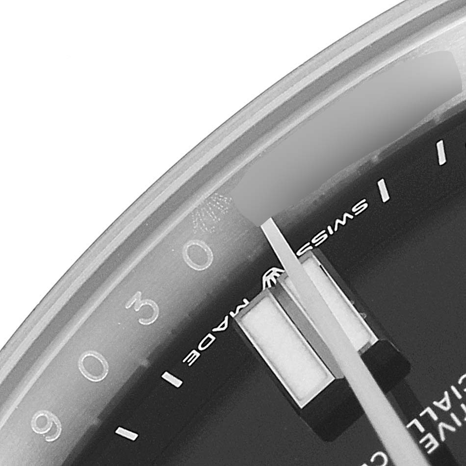 This close-up angle of the Rolex Oyster Perpetual 124300 Men's Stainless Steel Black Dial 124300 Men's Stainless Steel Black Dial watch shows part of the dial with hour markers and the "Swiss Made" label.