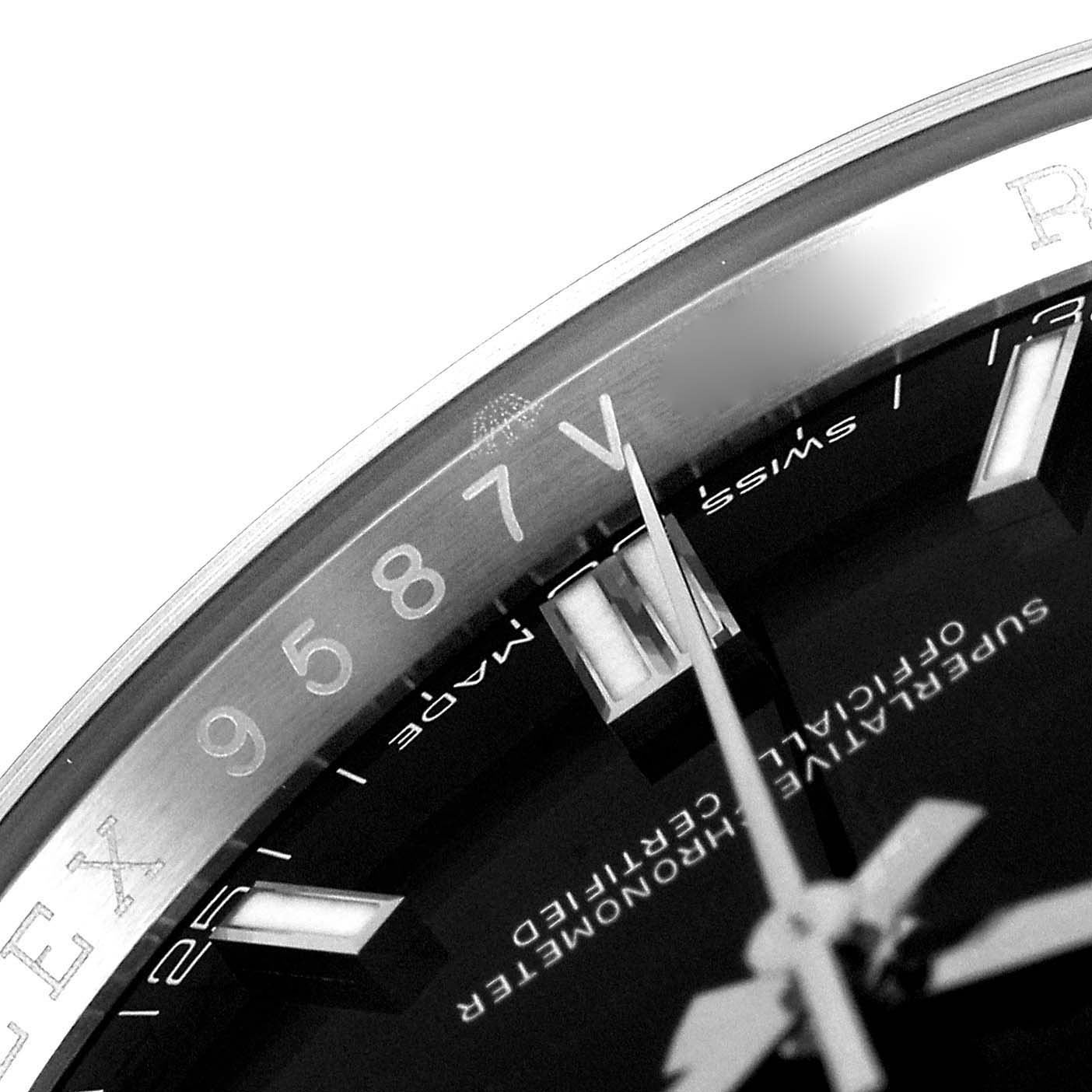 This close-up angle of a Rolex Oyster Perpetual 116000 Men
s Stainless Steel Black Dial 116000 Men
s Stainless Steel Black Dial watch shows part of the dial, hands, and engraved bezel.