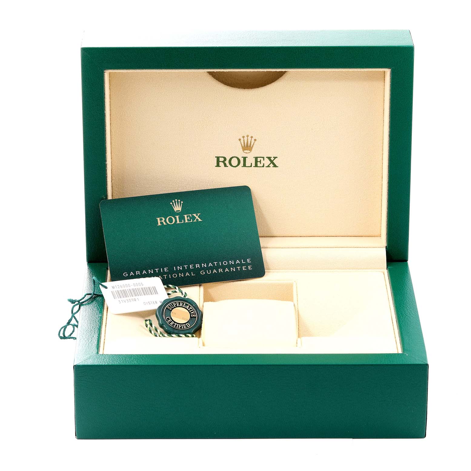 This image shows a green and beige Rolex box for an Oyster Perpetual model, displaying an international guarantee card and a certified tag.