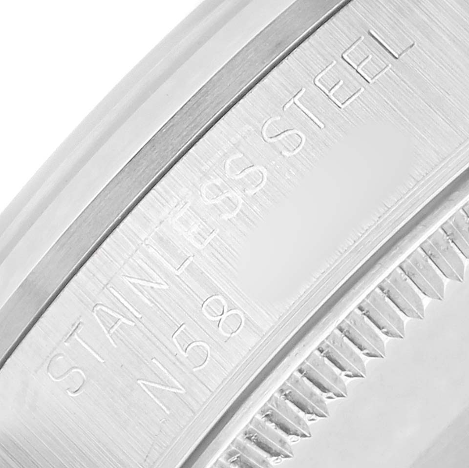 The image shows a close-up of a Rolex Mid-Size 67480 Women
s Stainless Steel Black Dial watch bezel with "STAINLESS STEEL" etched on the edge.